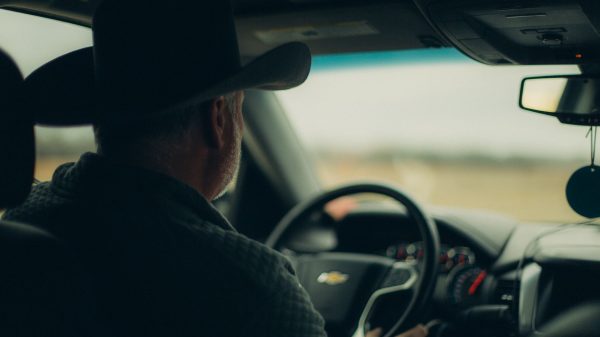 Senior Ohio driver on highway reviewing auto insurance coverage changes after 65