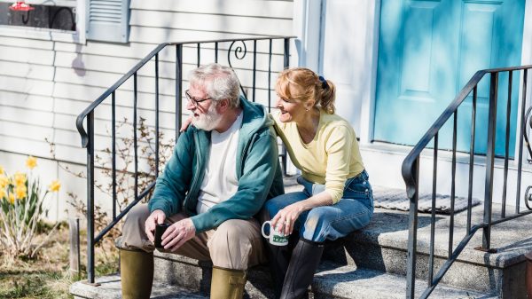 Retired Ohio homeowner couple standing in front of their home reviewing insurance tips