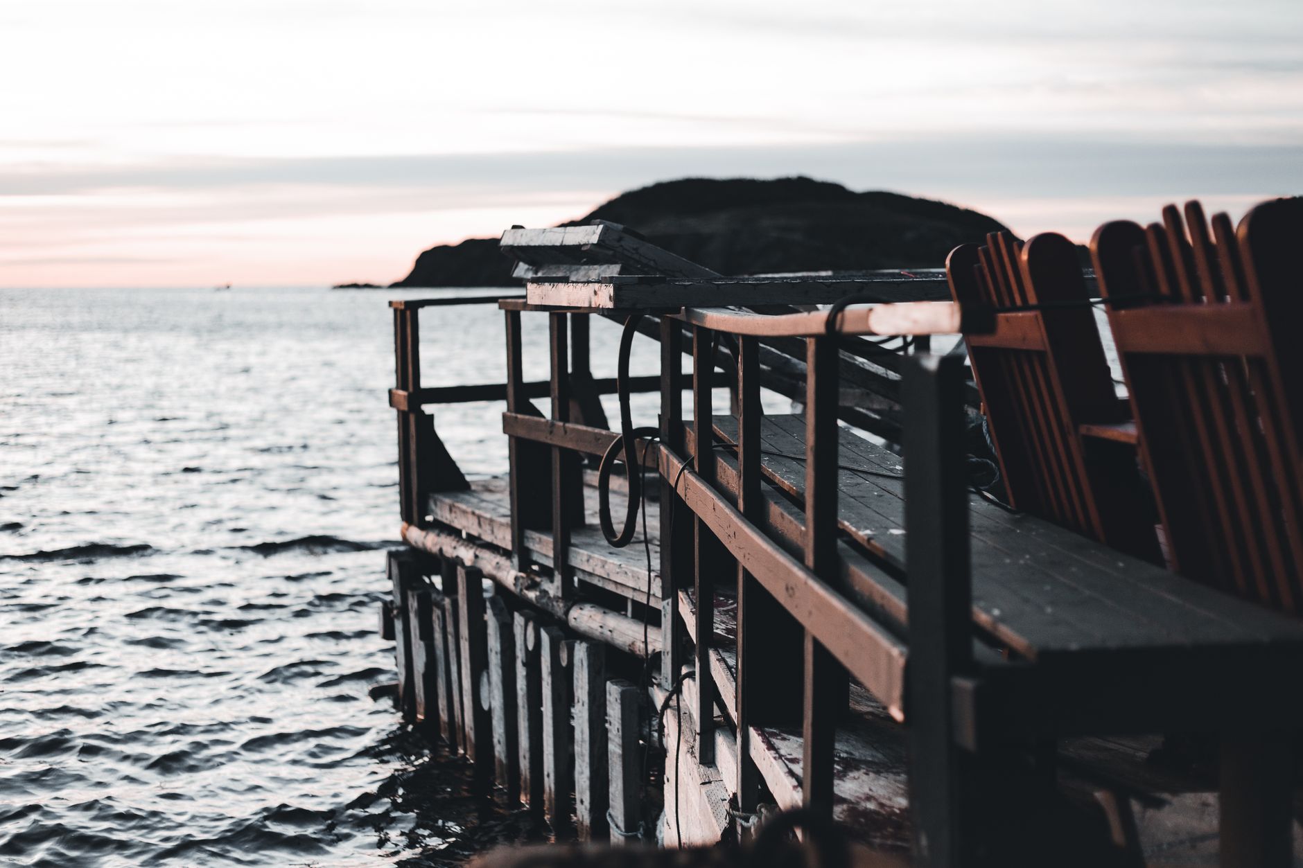 Outdoor chairs on a deck at sunset