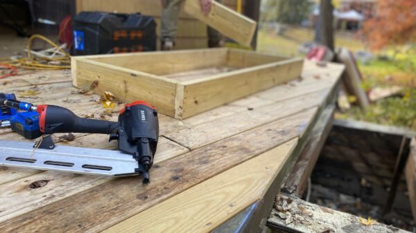 A nail gun on a deck under construction
