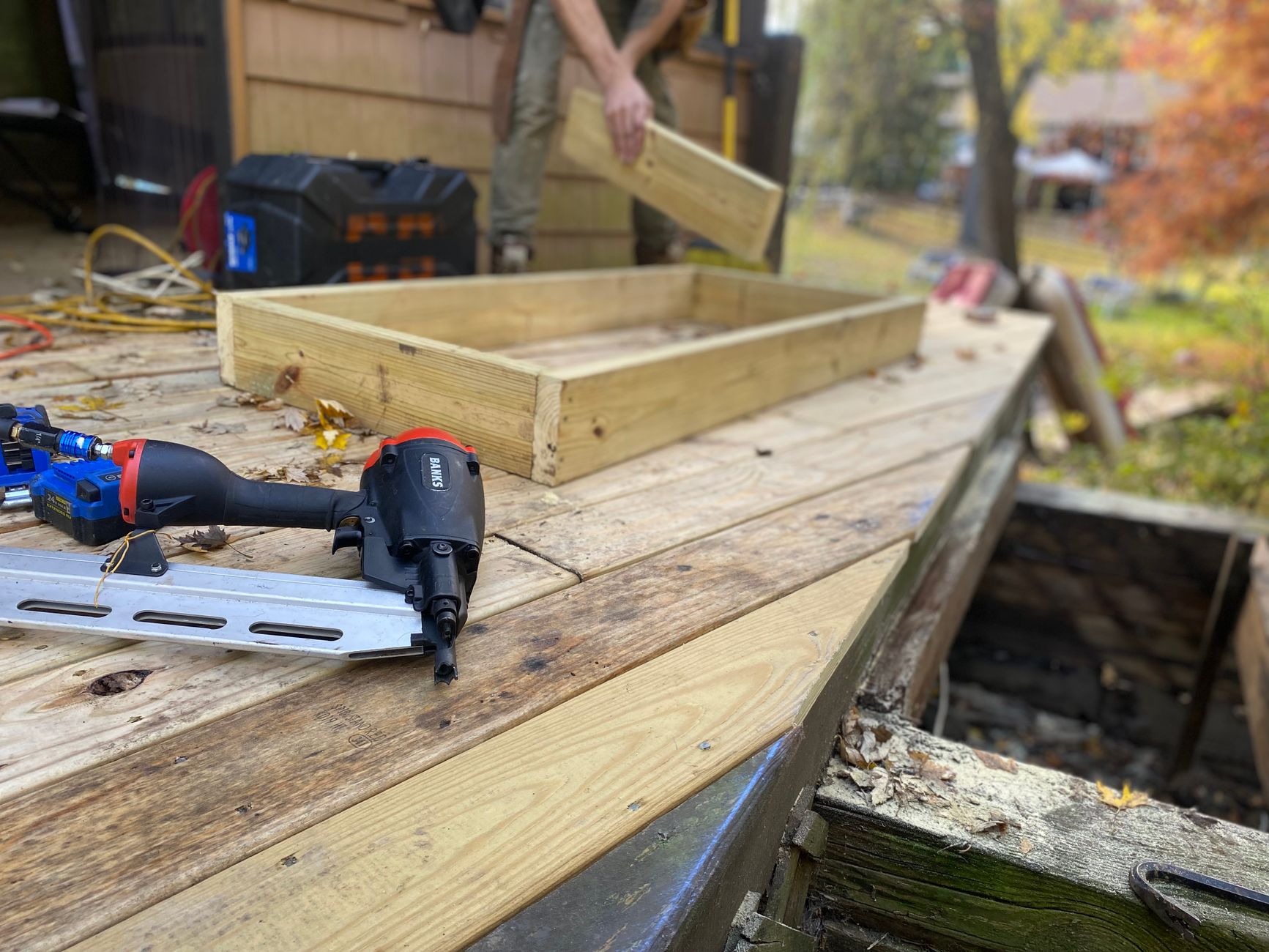 A nail gun on a deck under construction