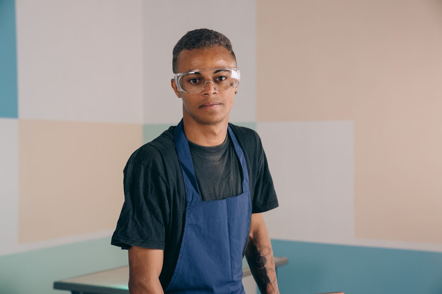 A man in safety glasses and a work apron