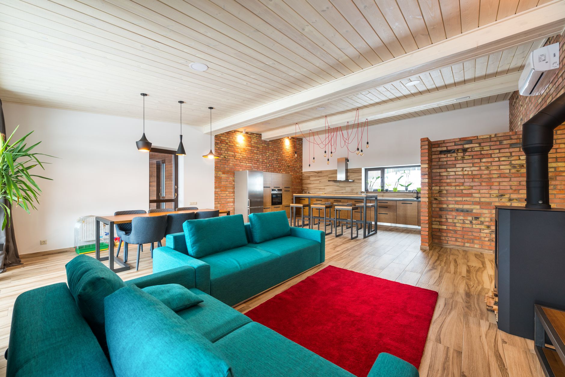 An open-plan living room with teal sofas
