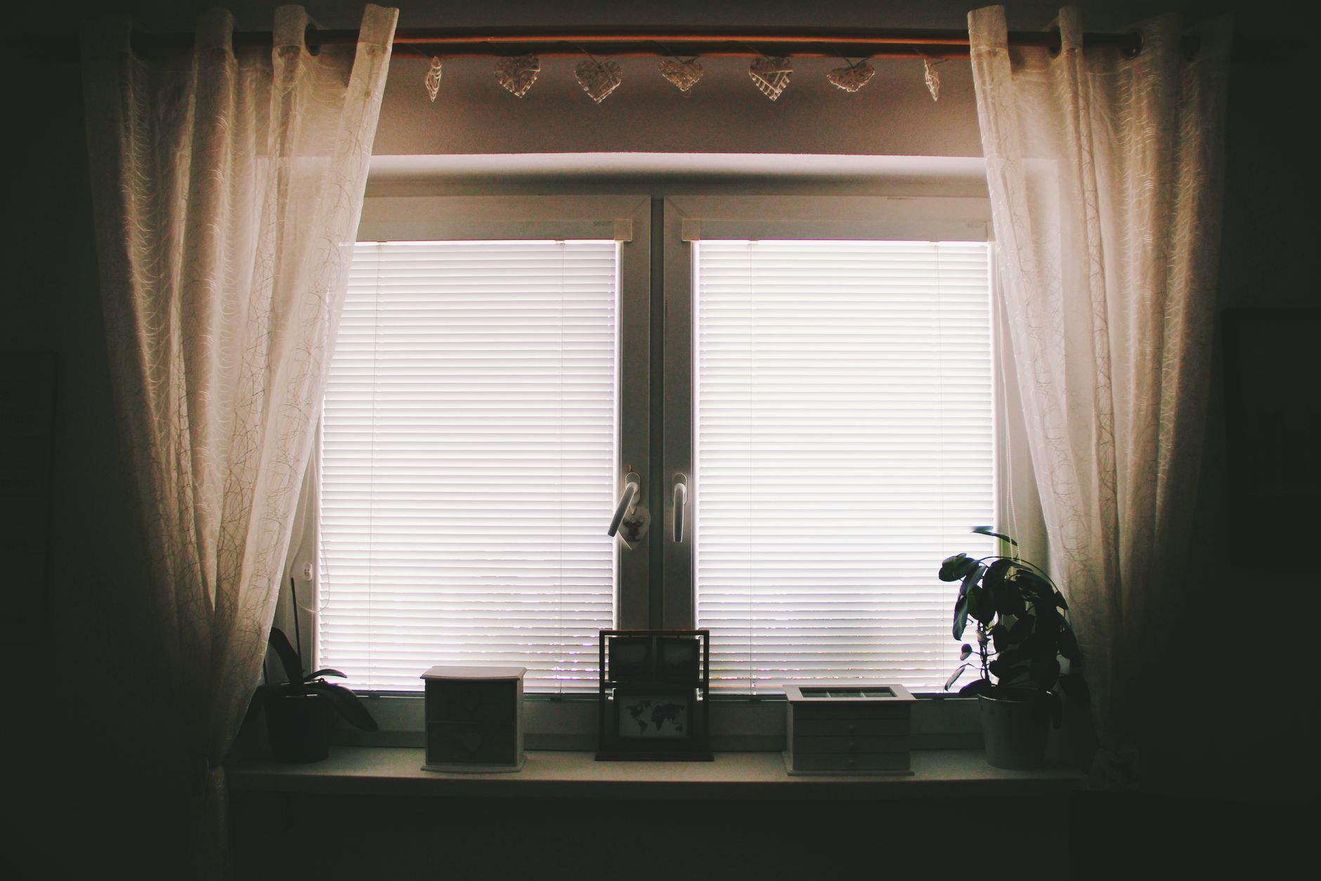 A curtained window with closed blinds