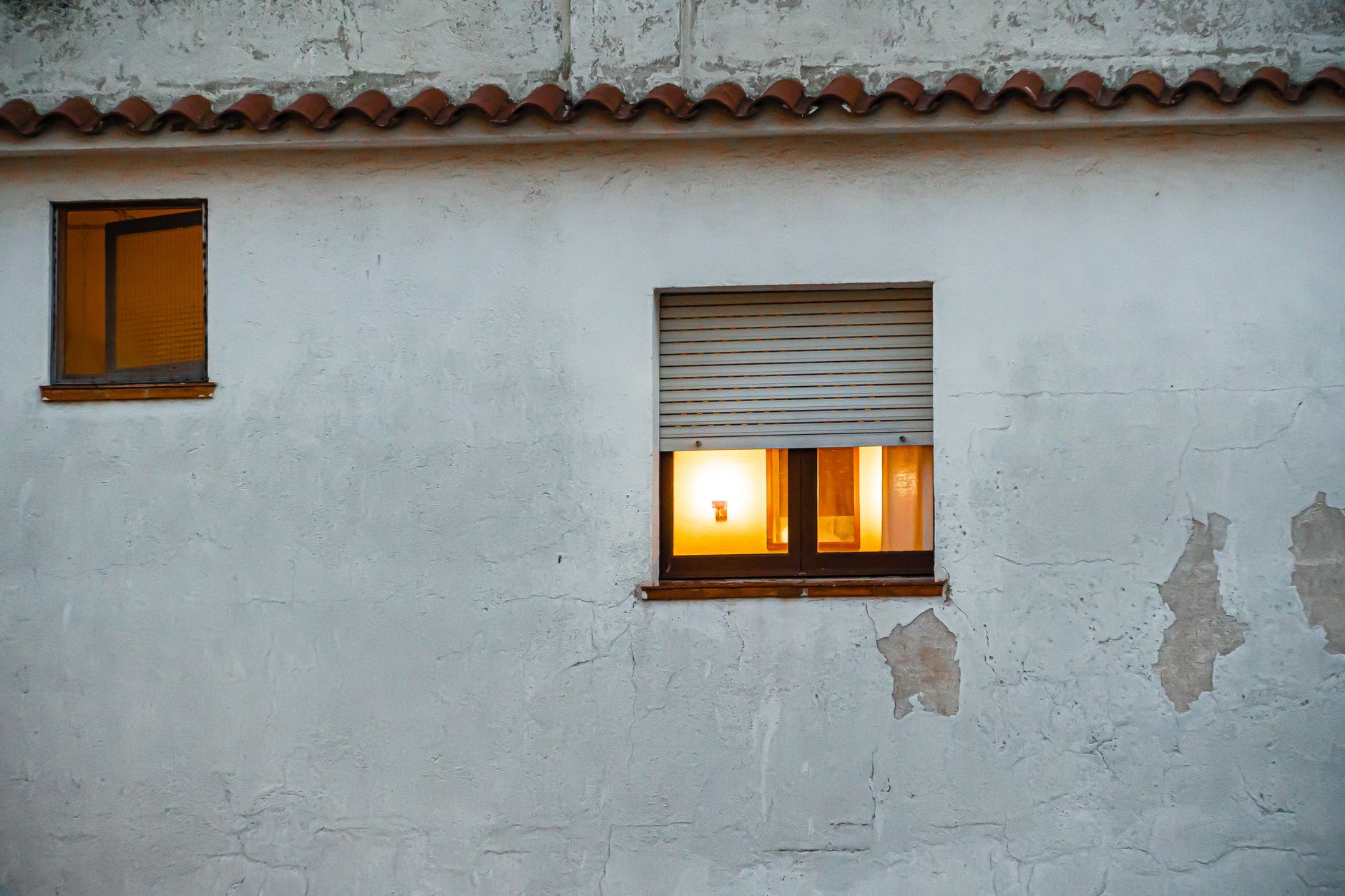 A lit window in an old plaster wall