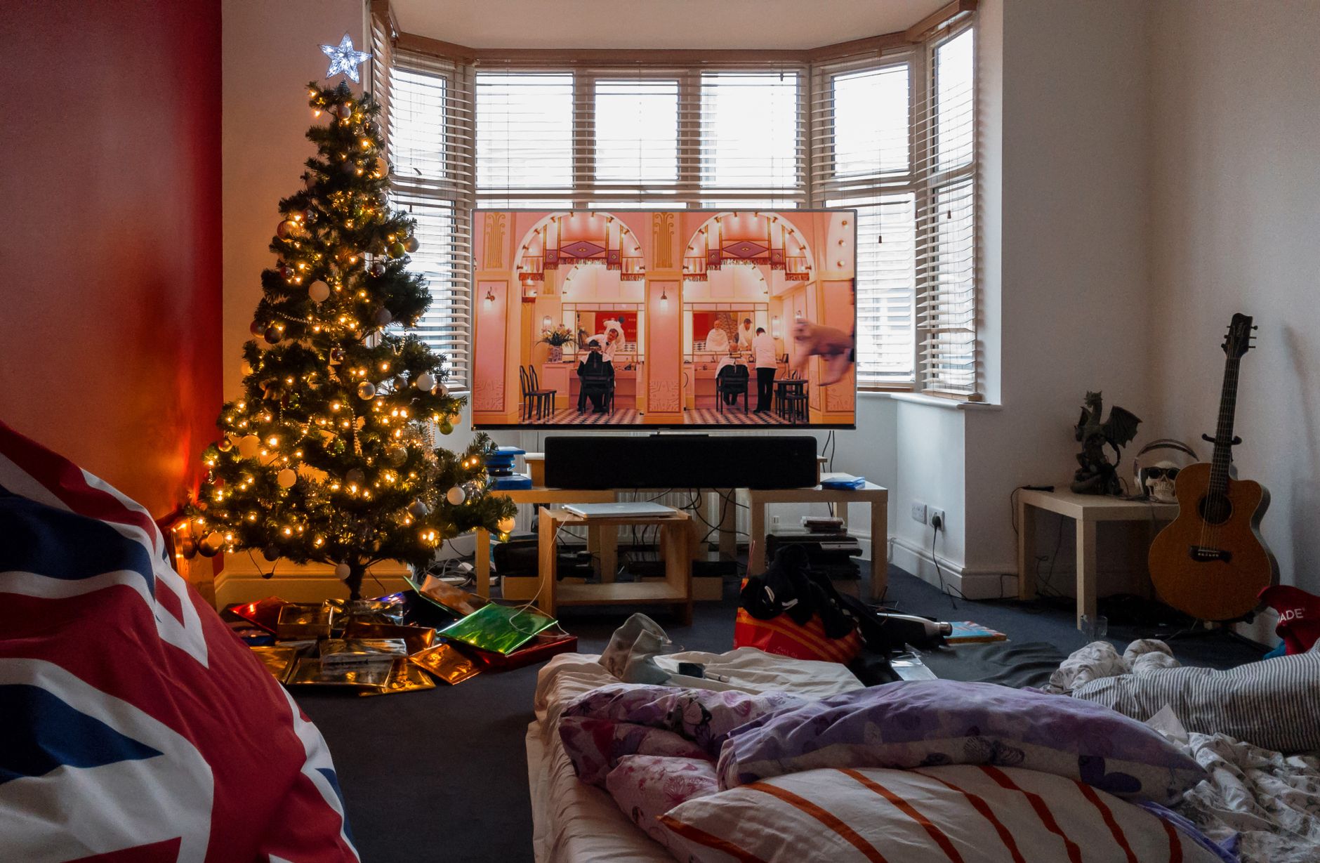 A lit tree by a bay window in a living room