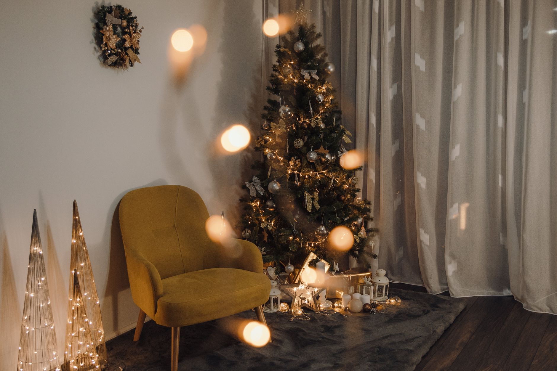 A lit tree and chair in a cozy corner