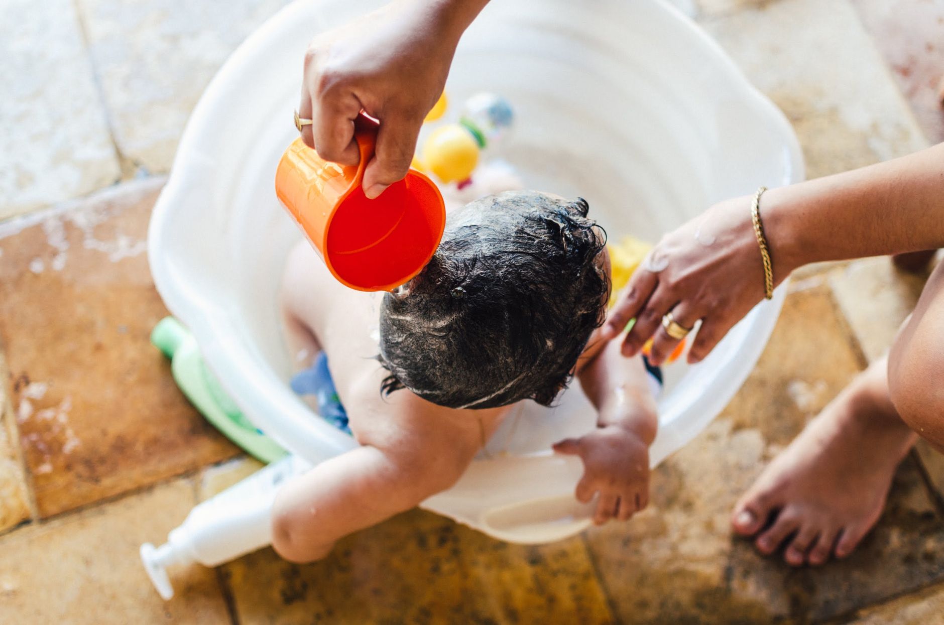 A baby being rinsed in a small tub