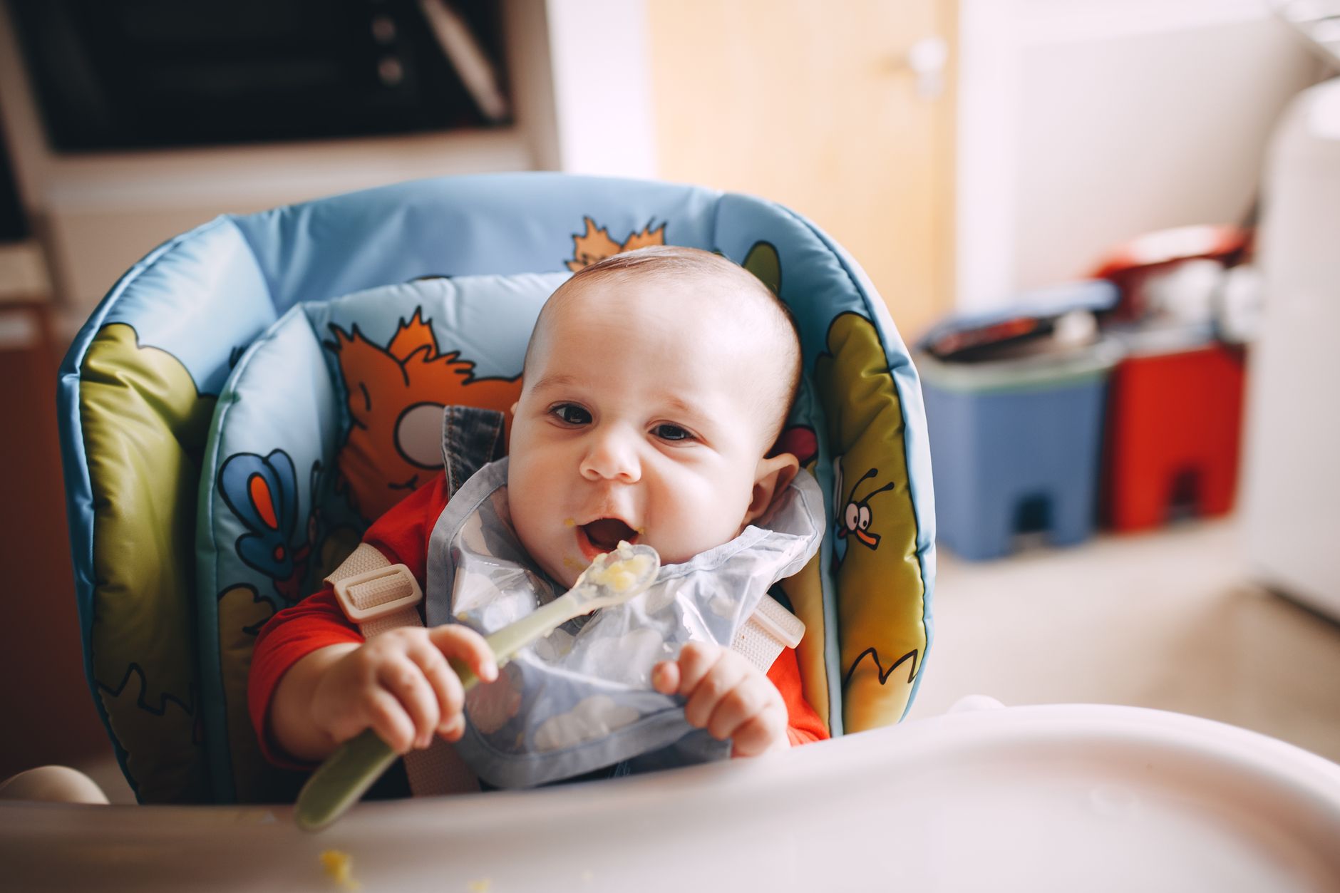 A baby feeding itself with a spoon