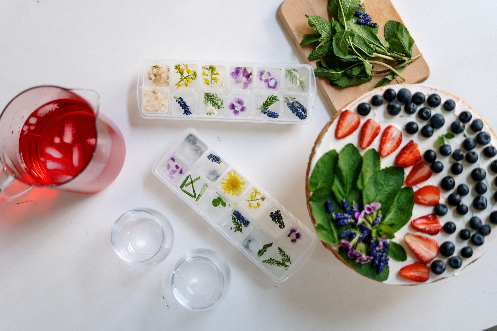 Ice cube trays with frozen flowers and fresh fruit
