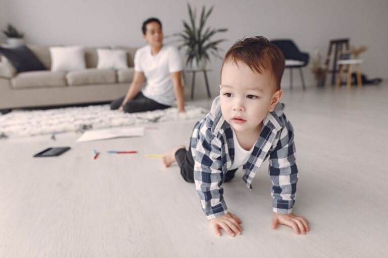 A toddler crawling on a living room floor