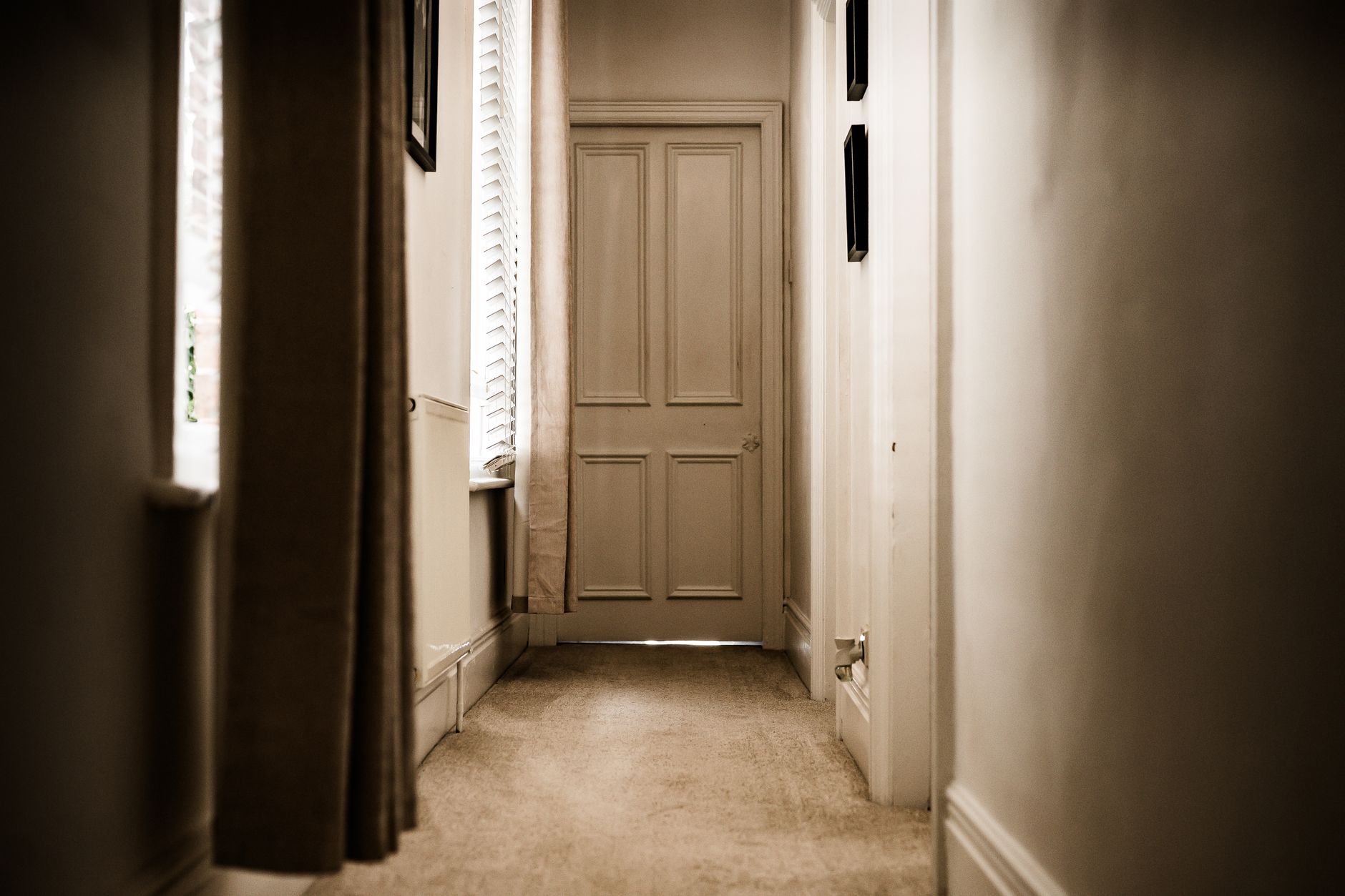 A long hallway leading to a closed door