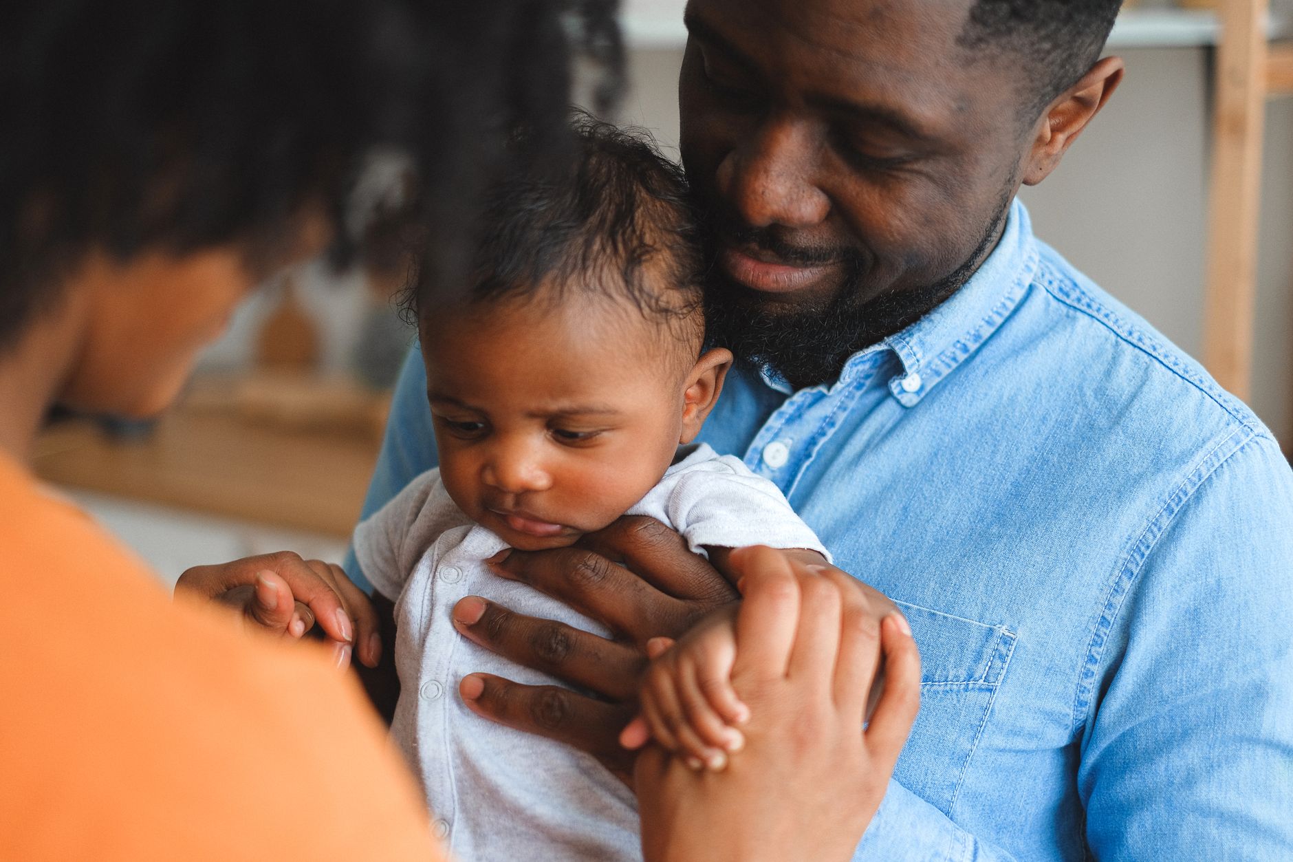 A father holding a baby close at home