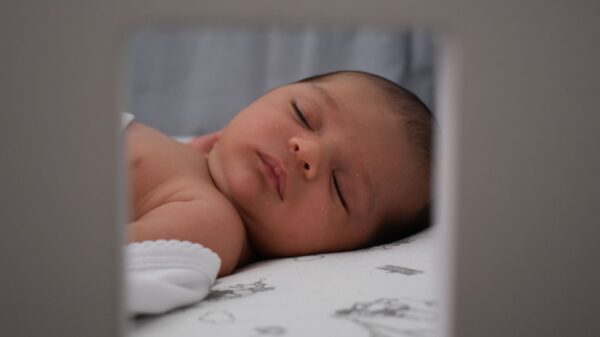 A sleeping newborn seen through a frame