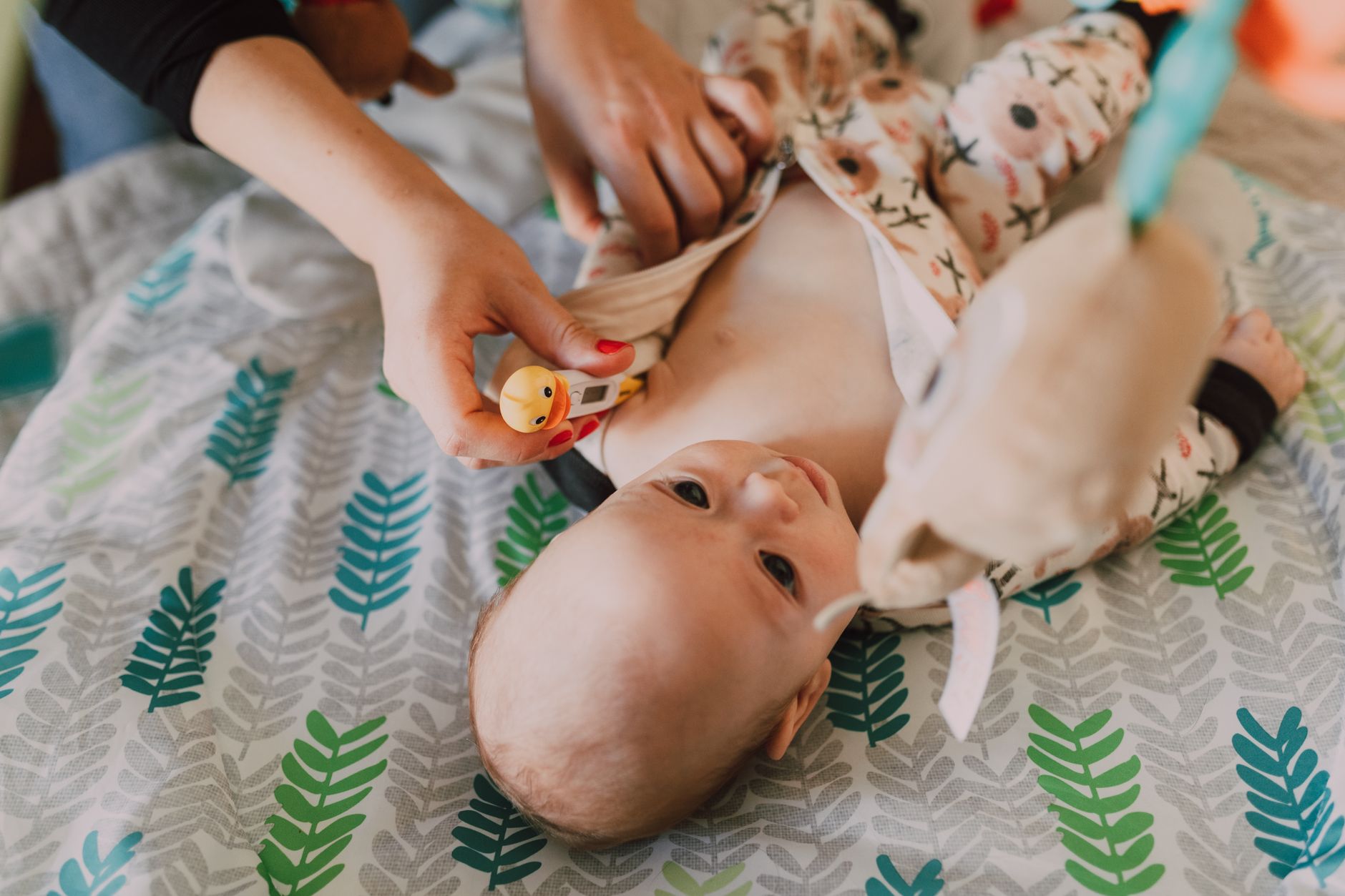 A baby on a changing pad with a parent