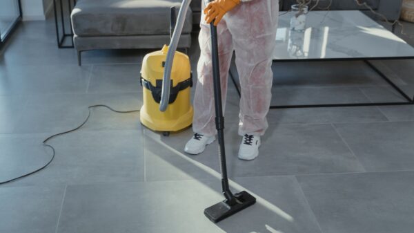 Best backpack vacuum: a worker in protective gear vacuuming a tile floor