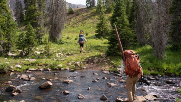 Best backpacking water filter: hikers crossing a mountain stream