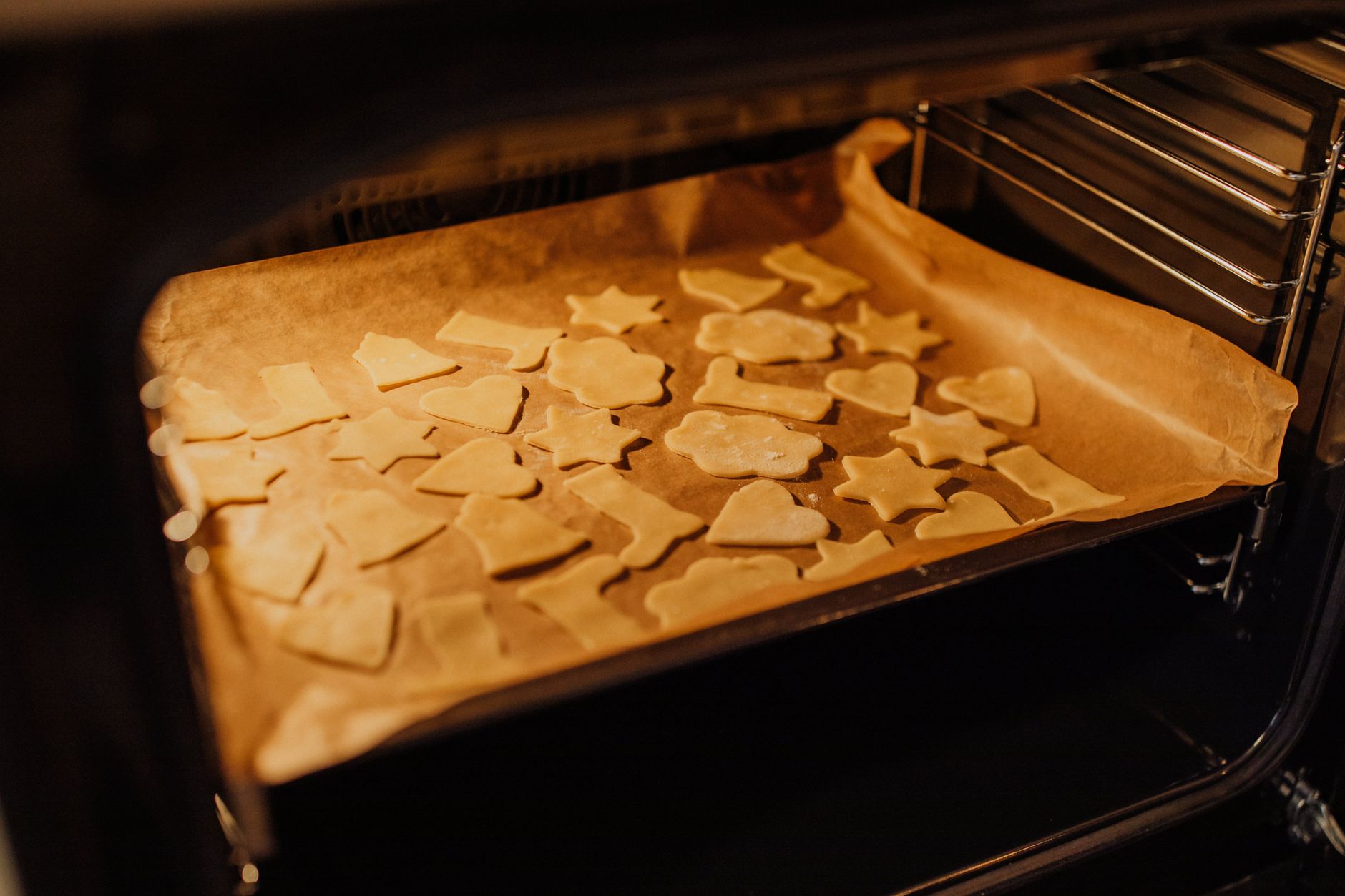 Cut-out cookies baking on a tray in an oven
