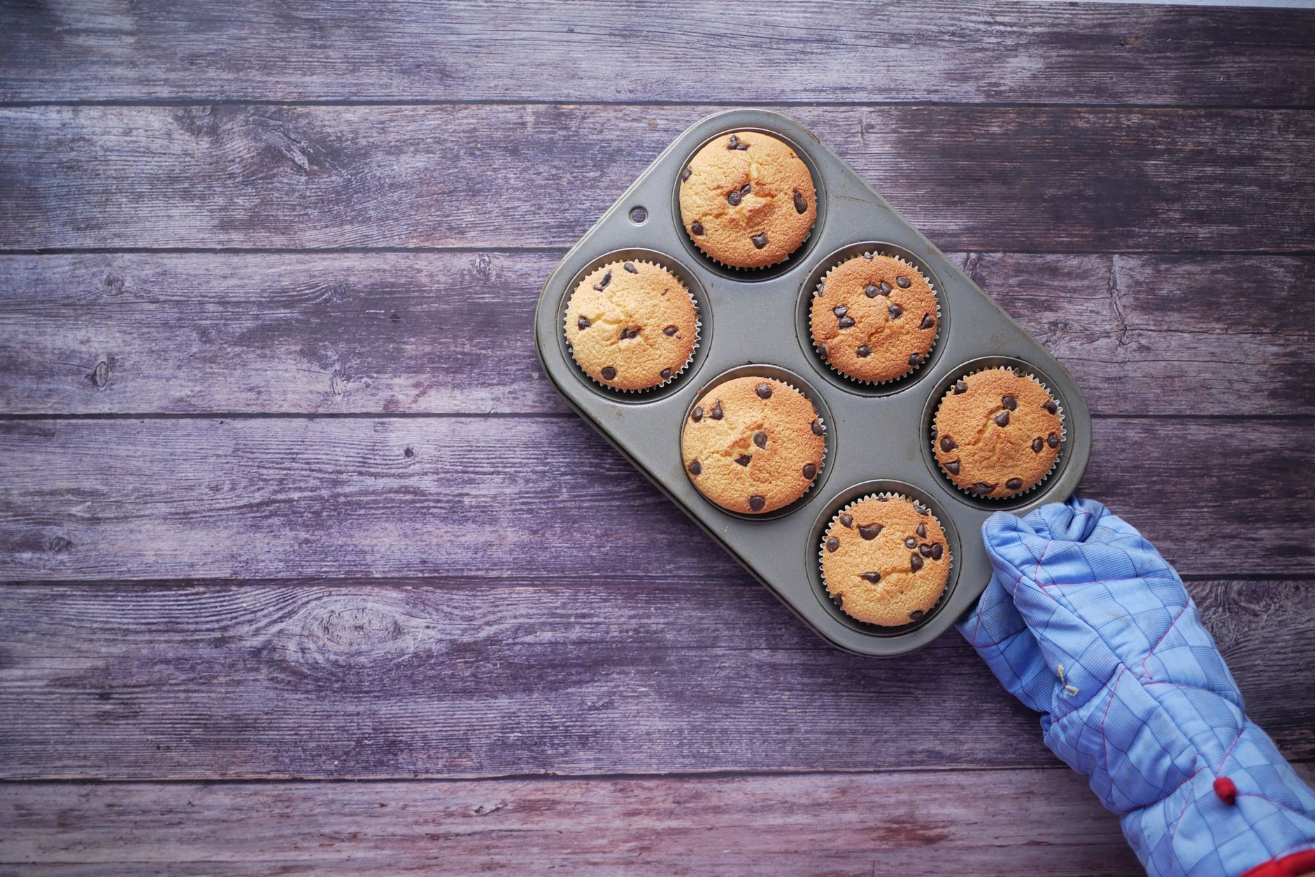 Lifting a muffin pan with an oven mitt