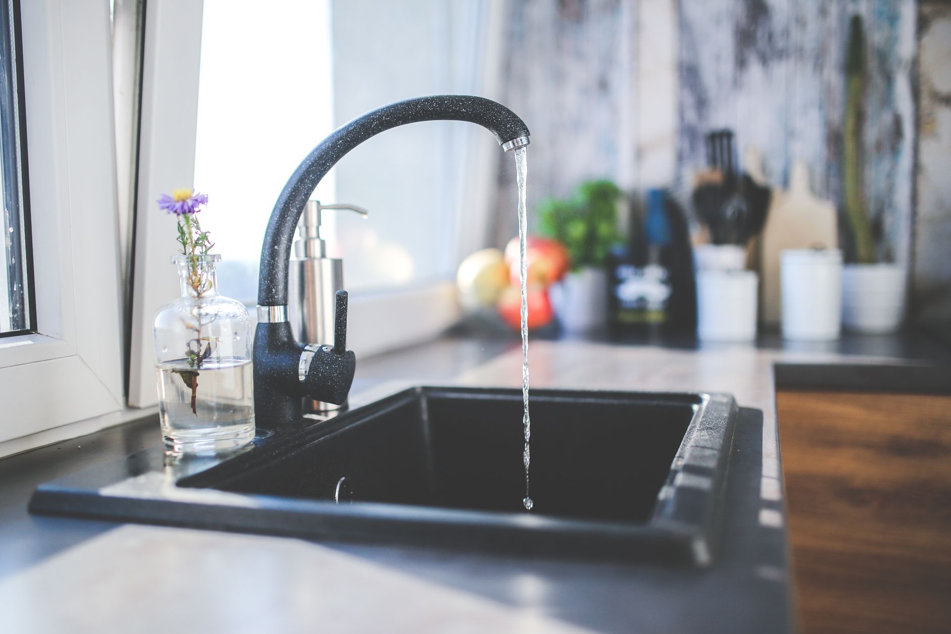Water running from a black faucet into a sink