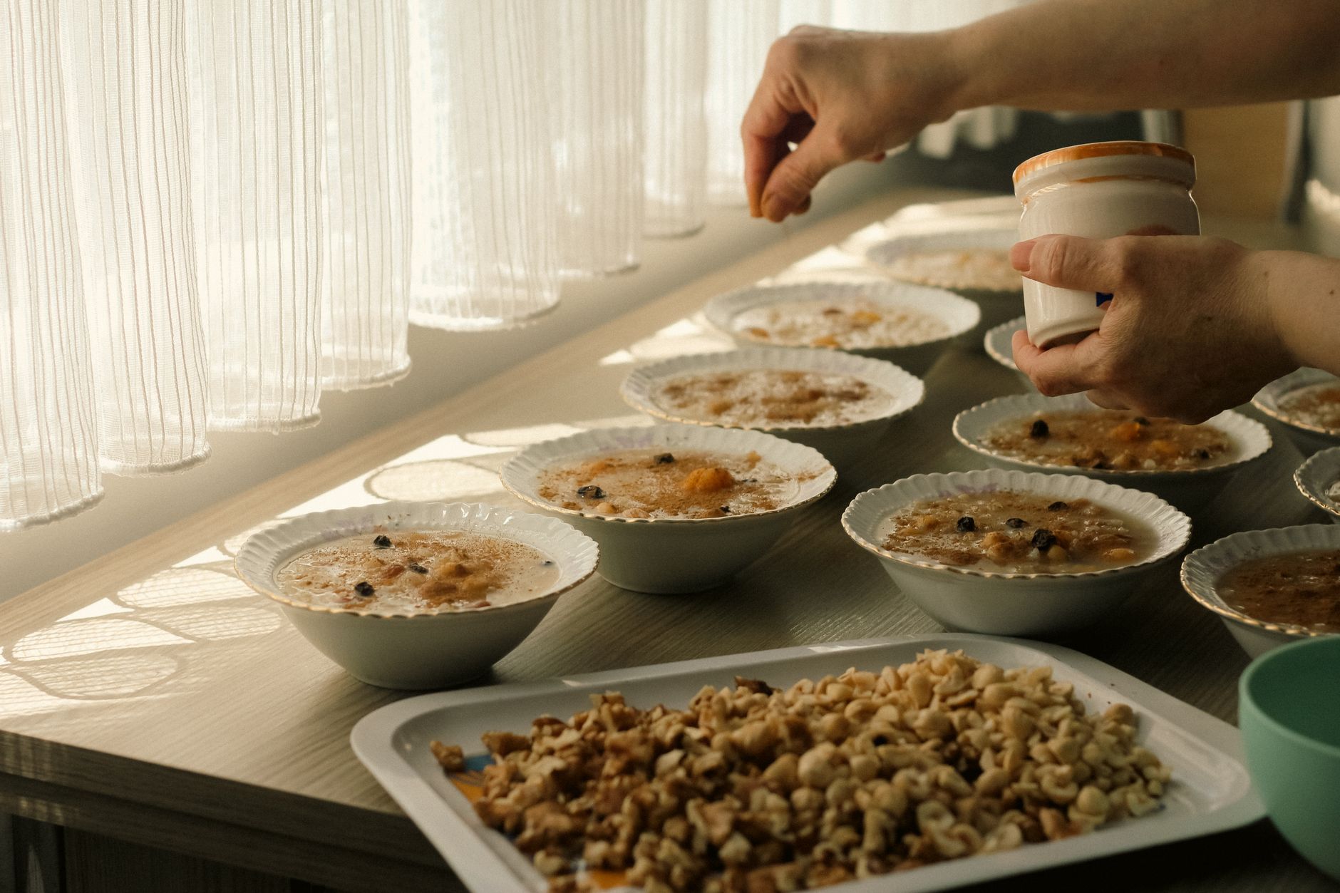 Bowls of oatmeal being topped with nuts