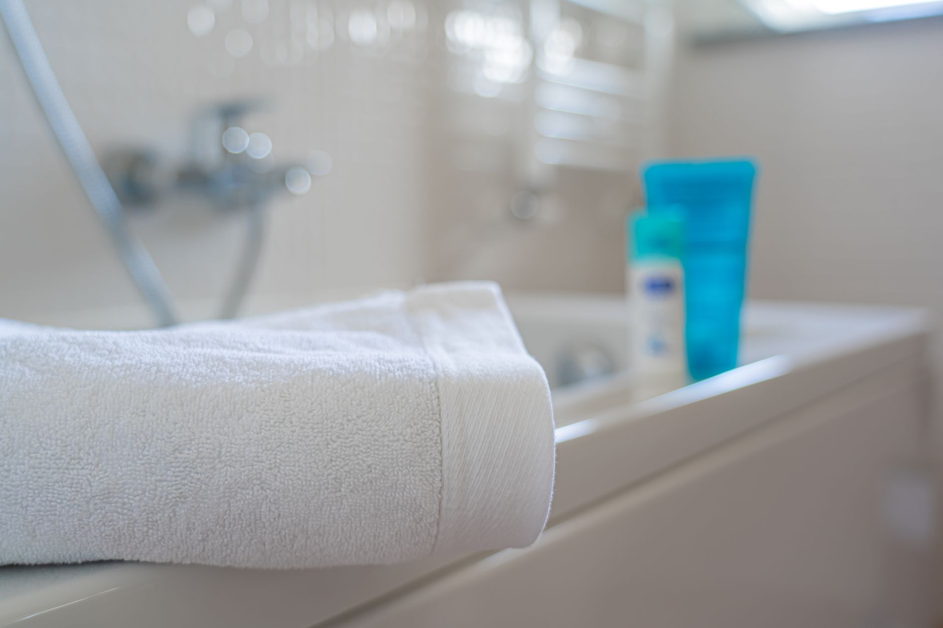 Best bathtub cleaner: a towel and bottles on a tub edge