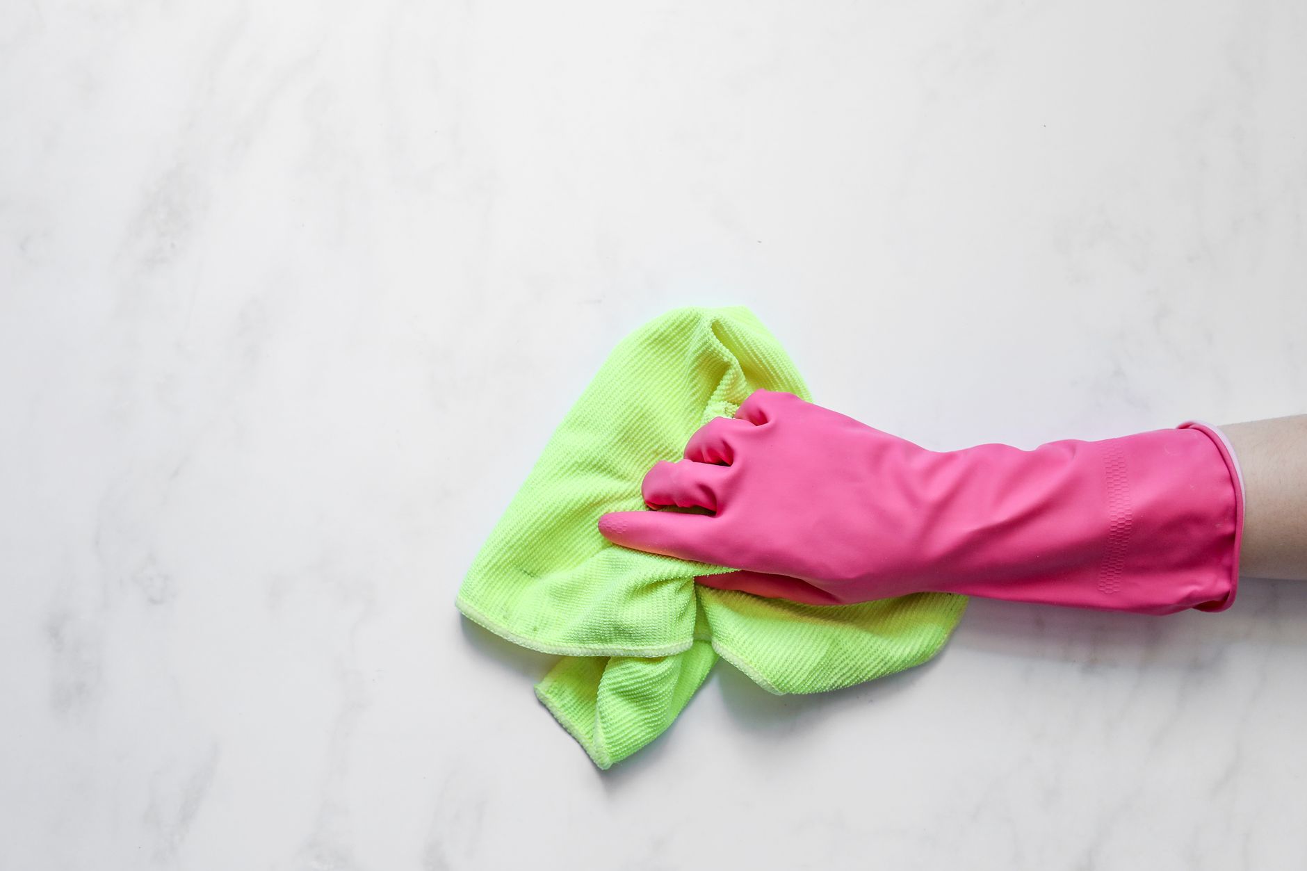 Gloved hand wiping a marble surface