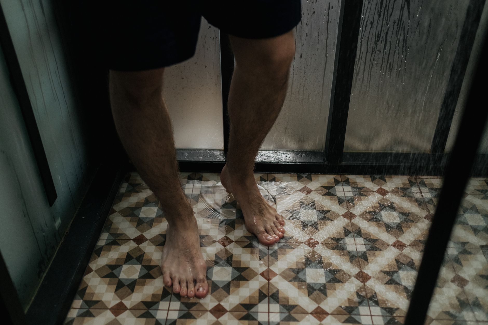 Bare feet on a wet patterned shower floor