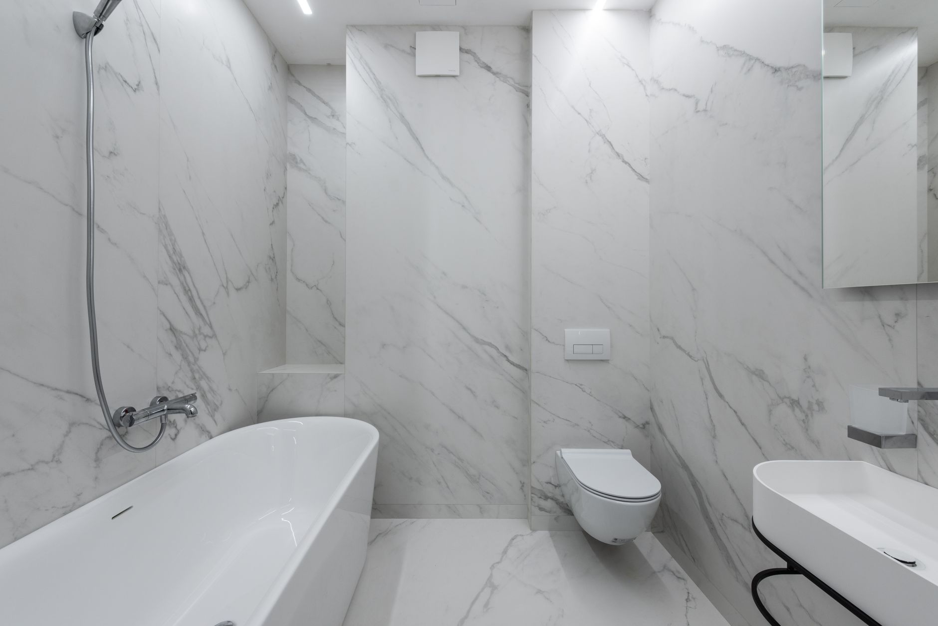 Best bathtub refinishing kit: a white tub in a marble bathroom