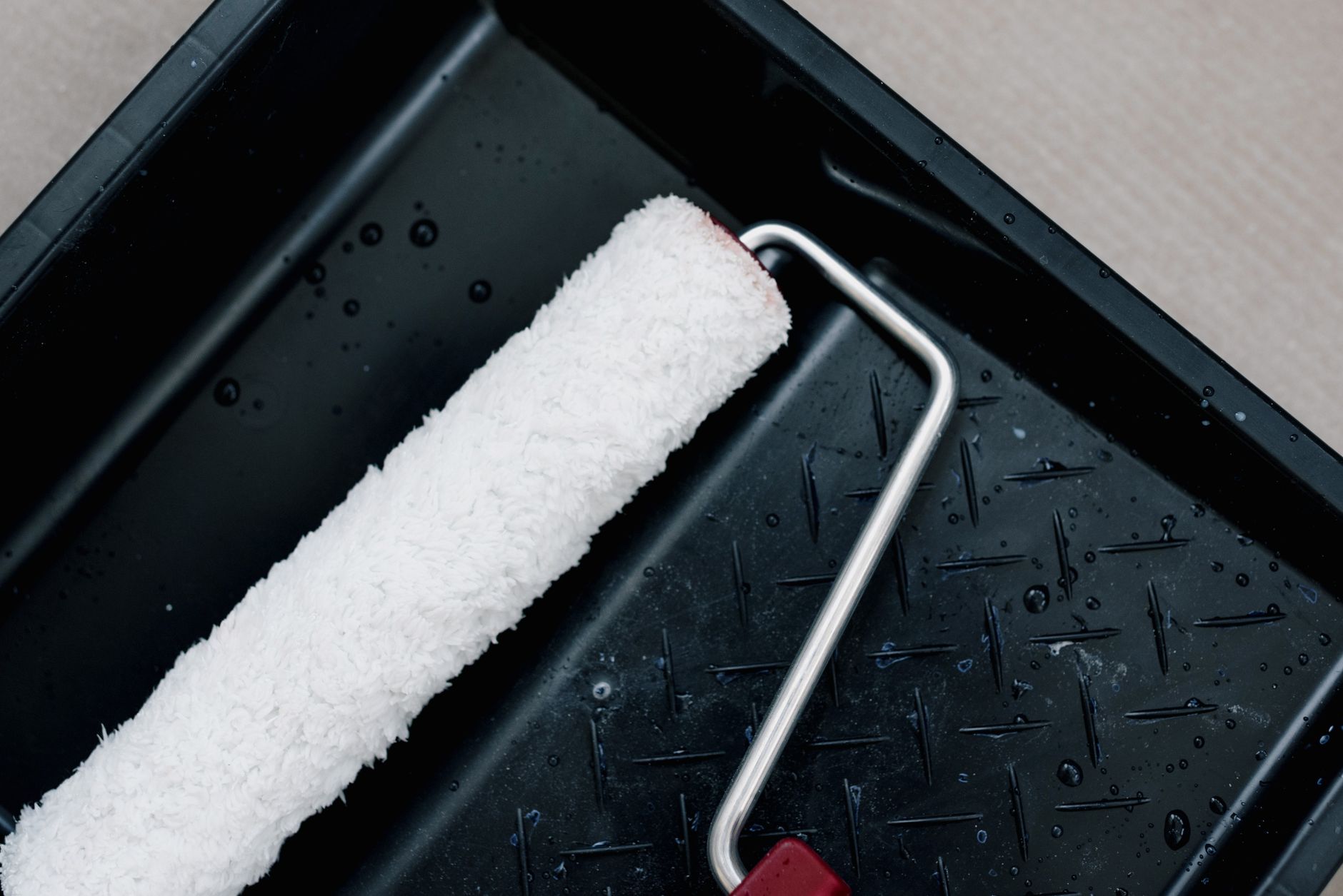 A paint roller in a tray
