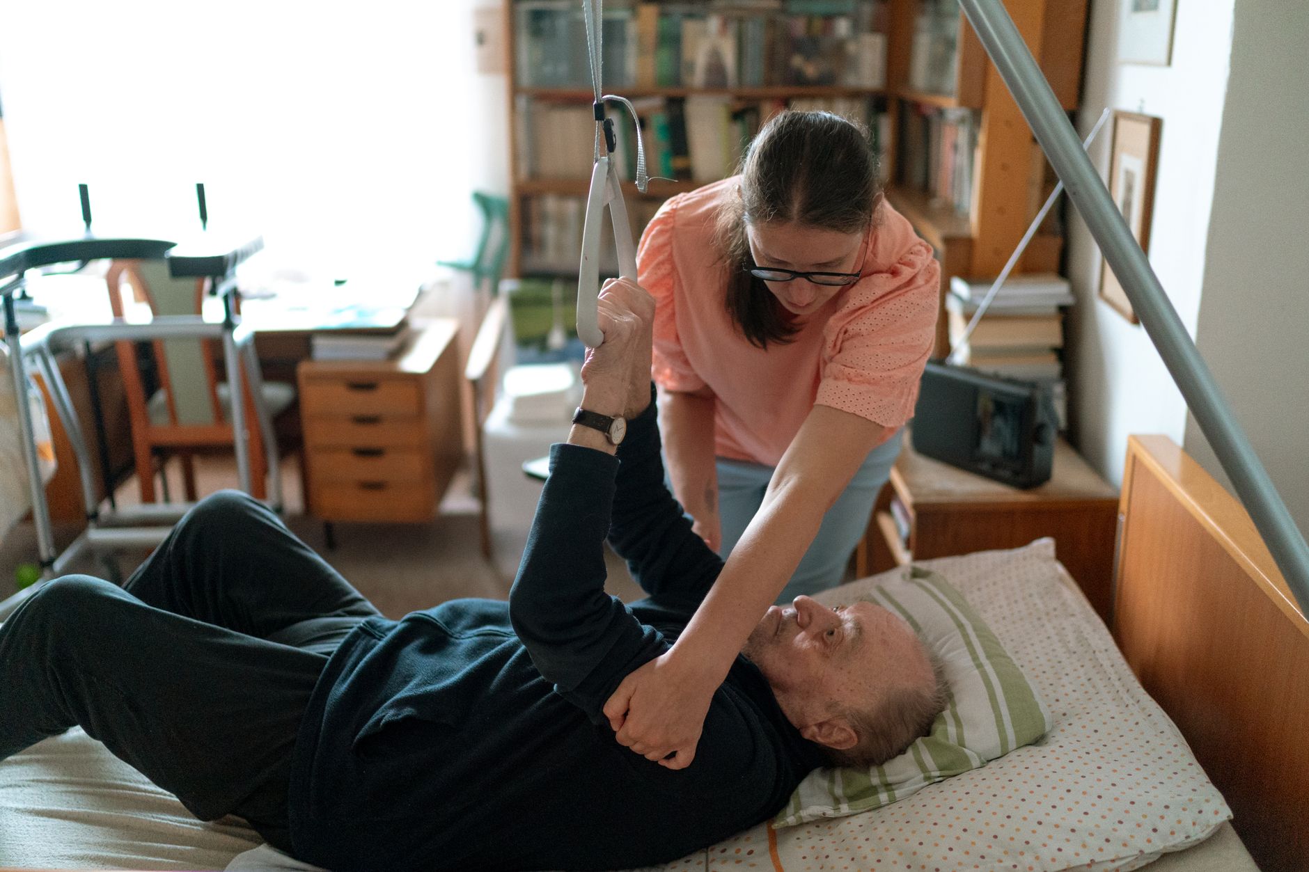 A caregiver helping an older man in bed