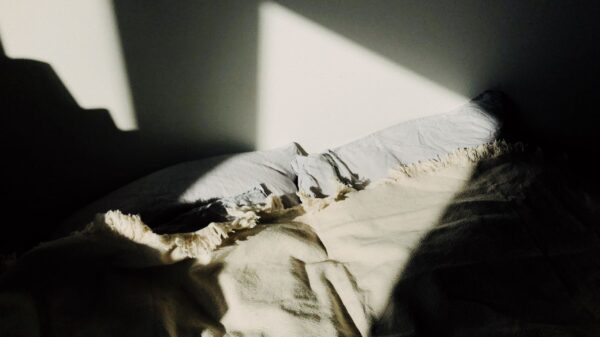 Sunlight falling across an unmade bed