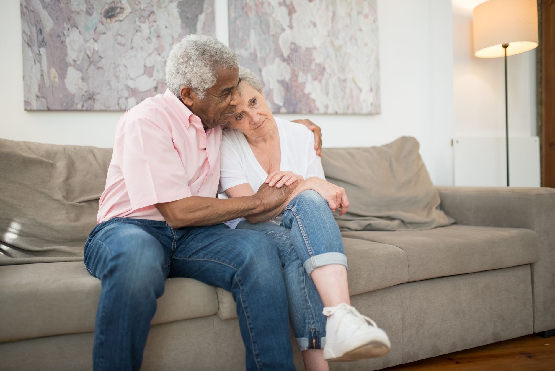 An older couple sitting close together on a sofa