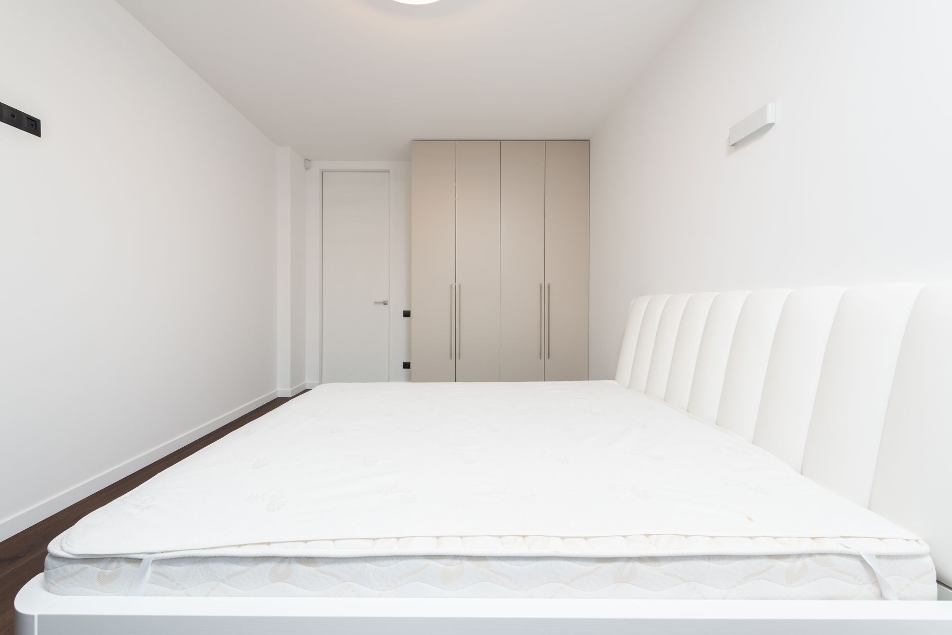 A bare mattress on a low bed frame