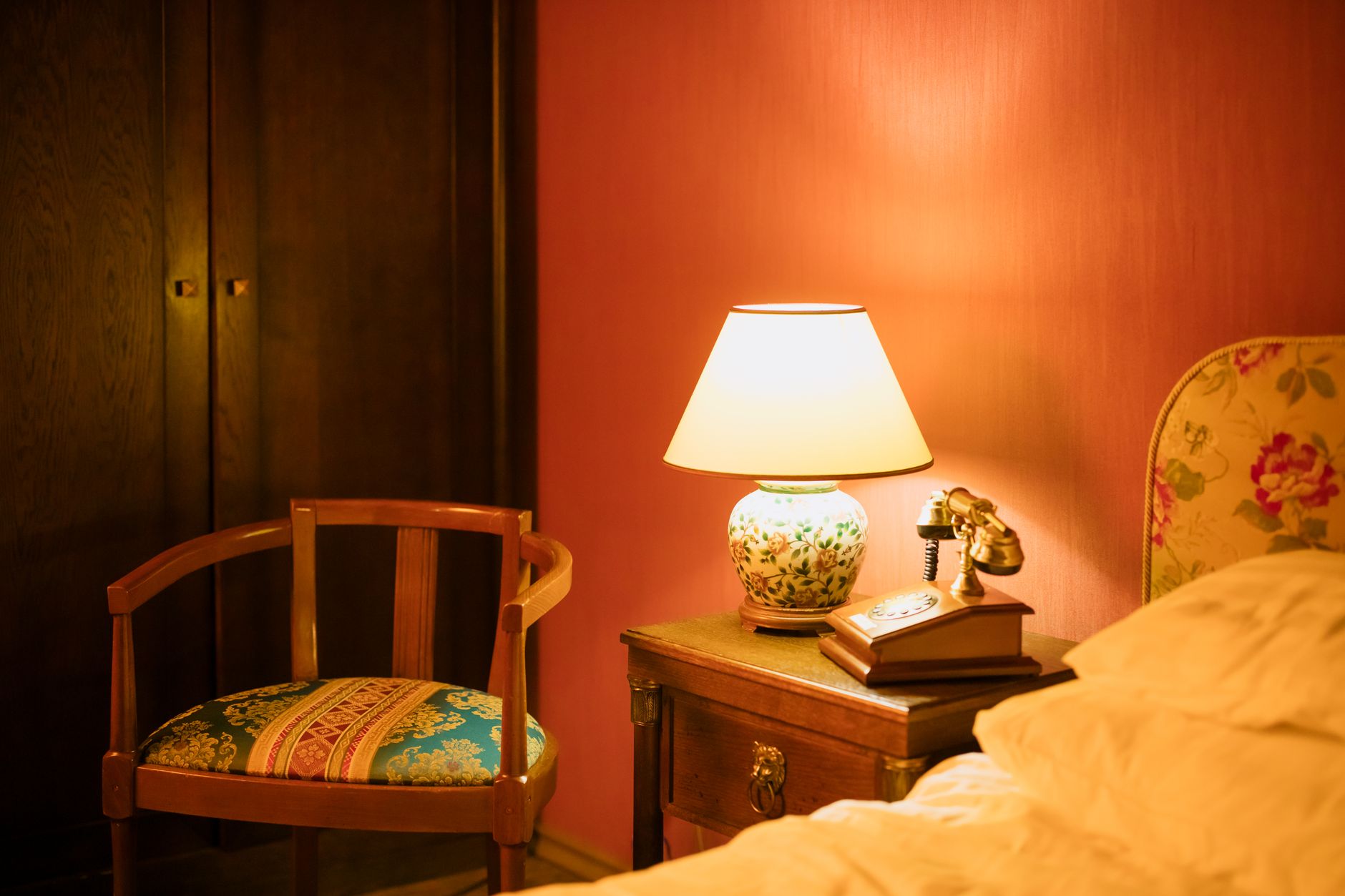 A bedroom lit by a lamp at night