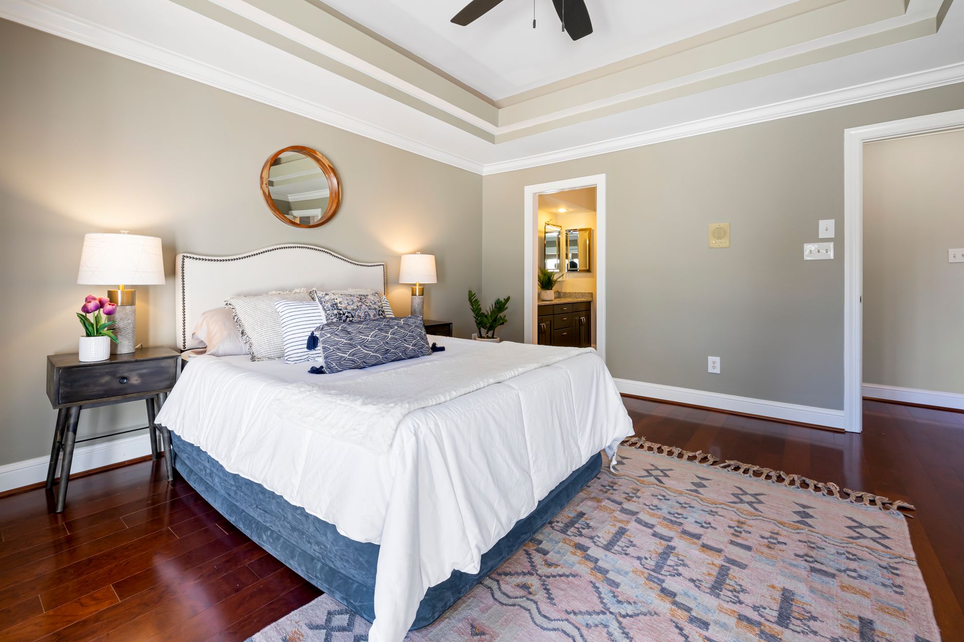 A bedroom with a made bed and lamps