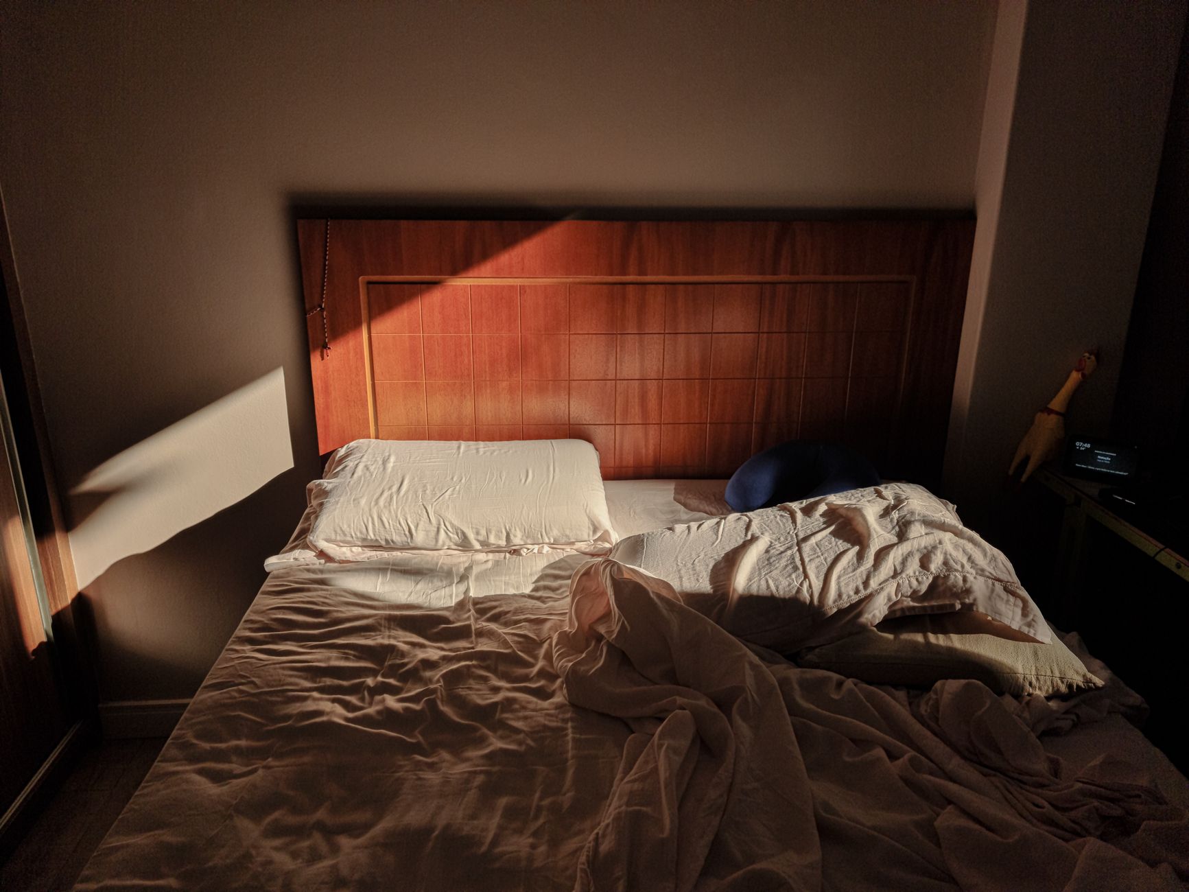 An unmade bed in a dark room