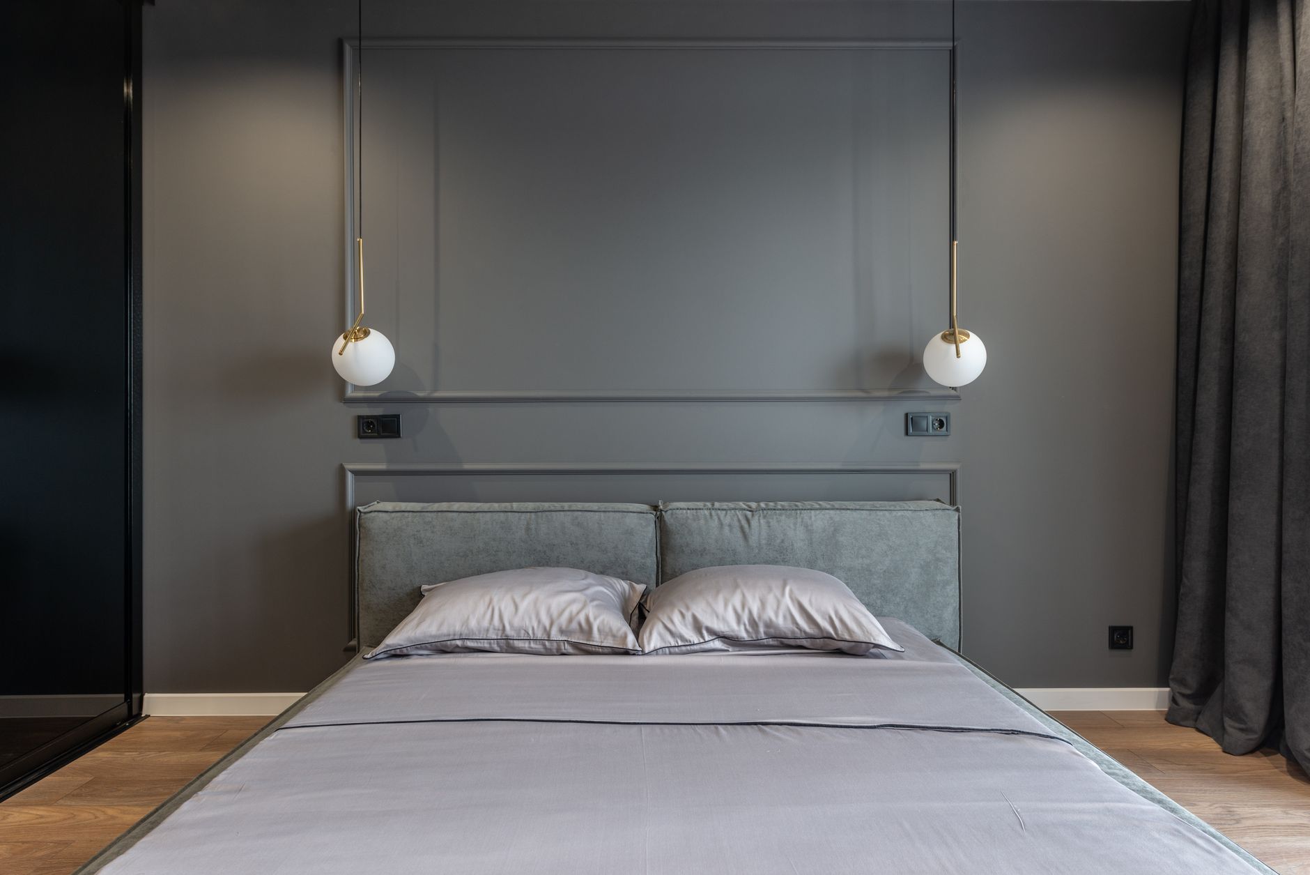 A neatly made bed in a gray bedroom