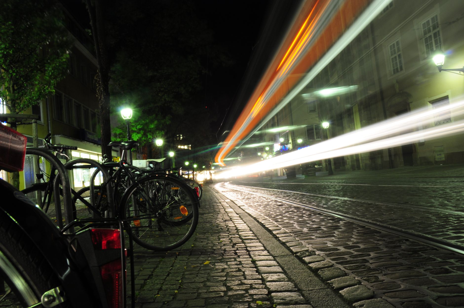 A bicycle on a street in the evening with lights