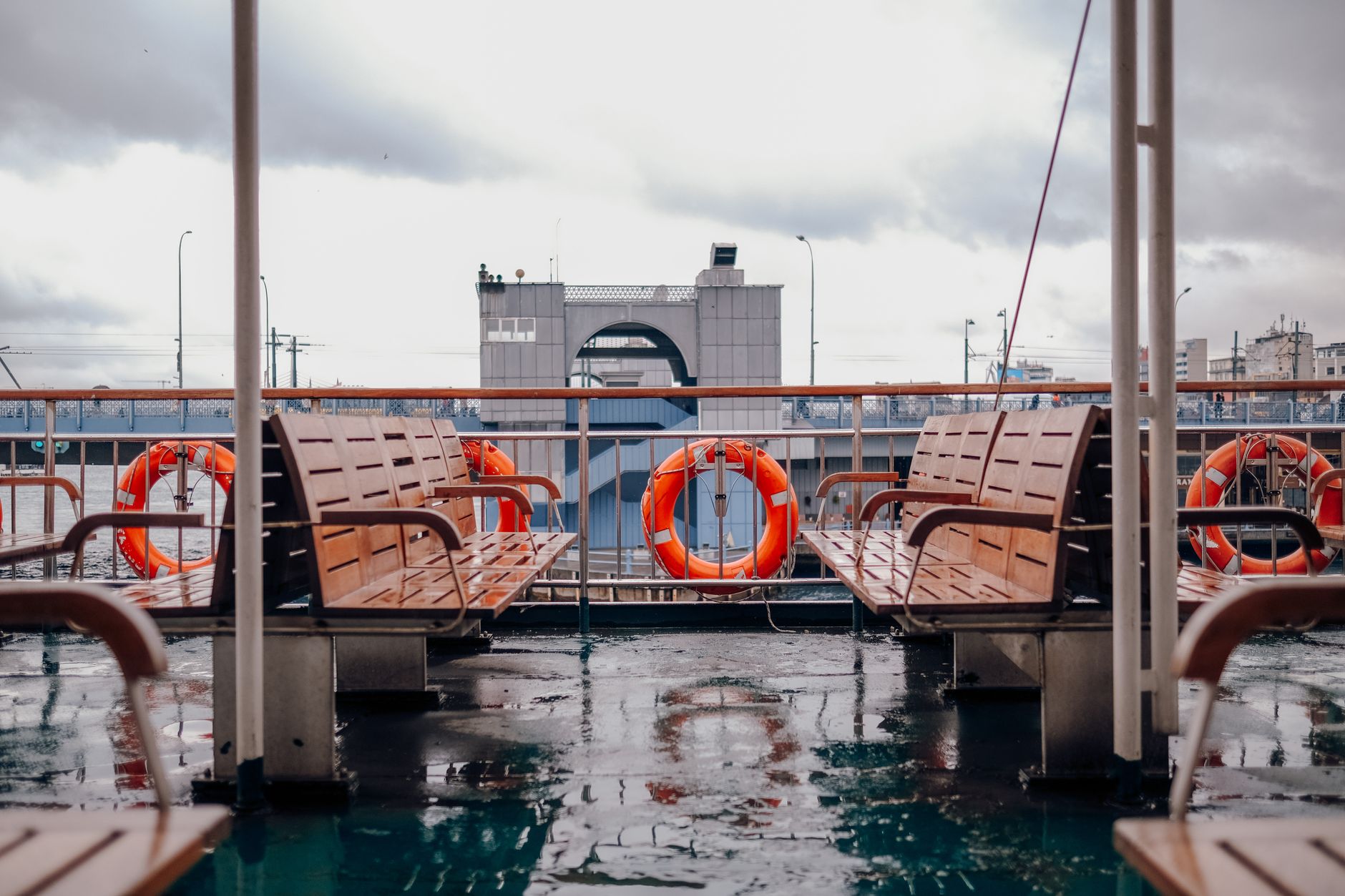 Ring buoys and benches on a rainy boat deck
