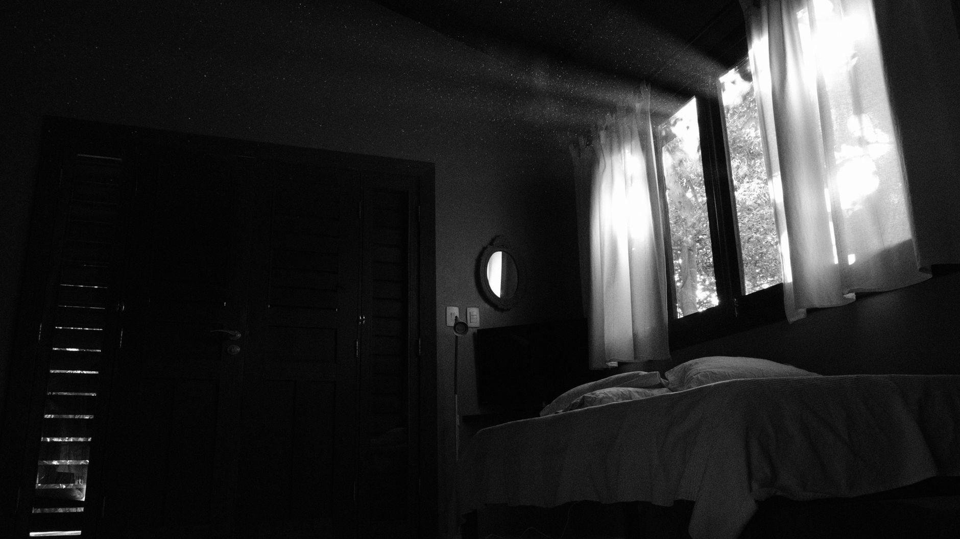 Curtains glowing at a window in a dark bedroom