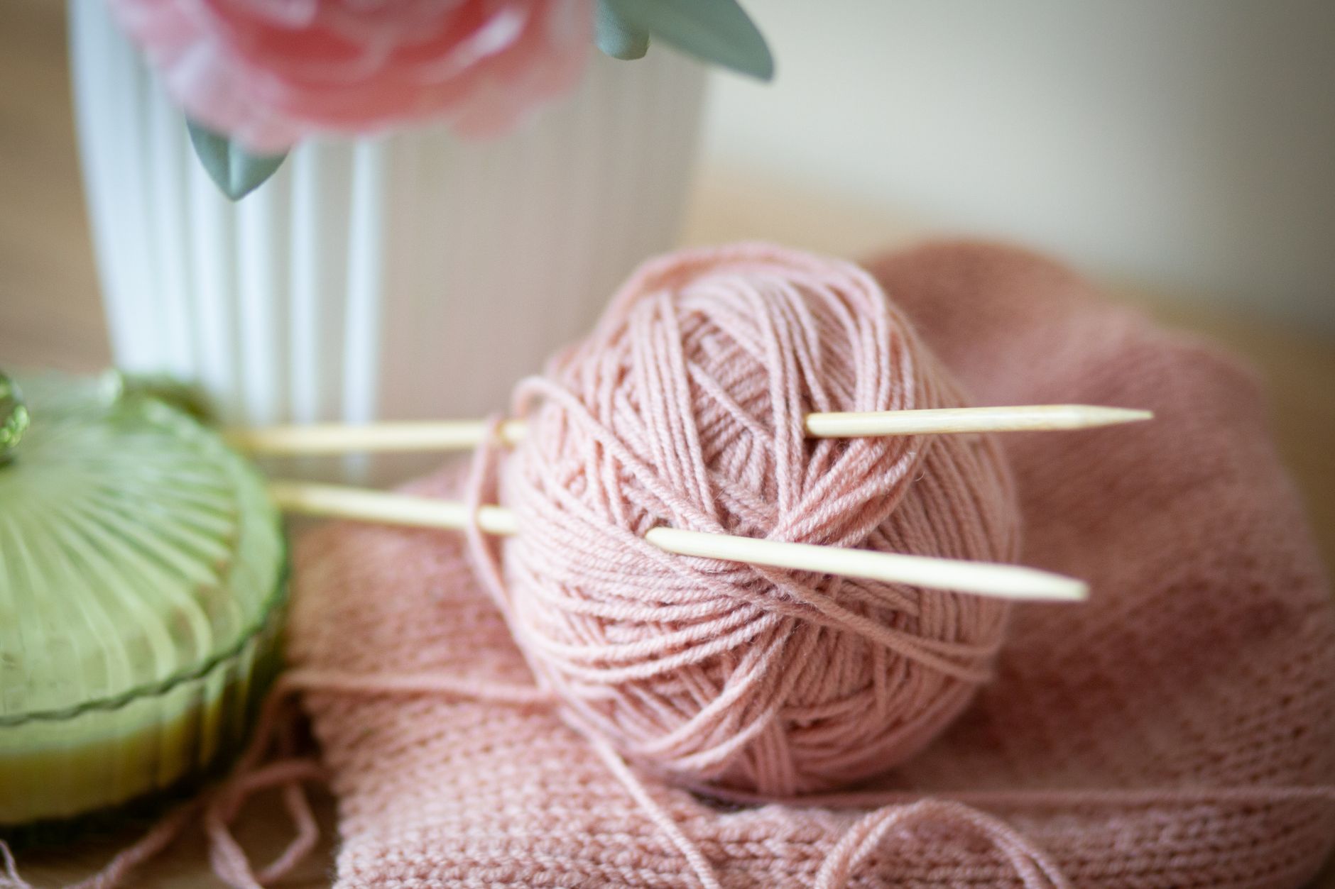 Knitting needles and yarn on a cozy blanket