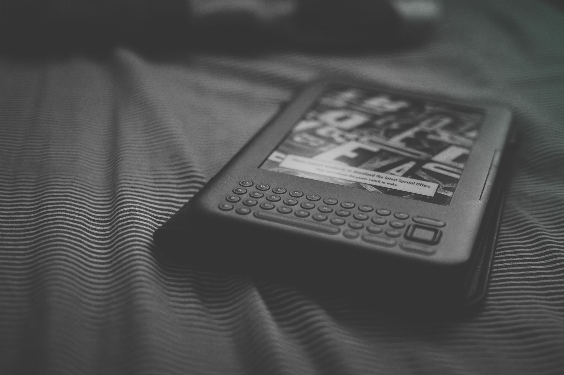 An e-reader resting on a bed