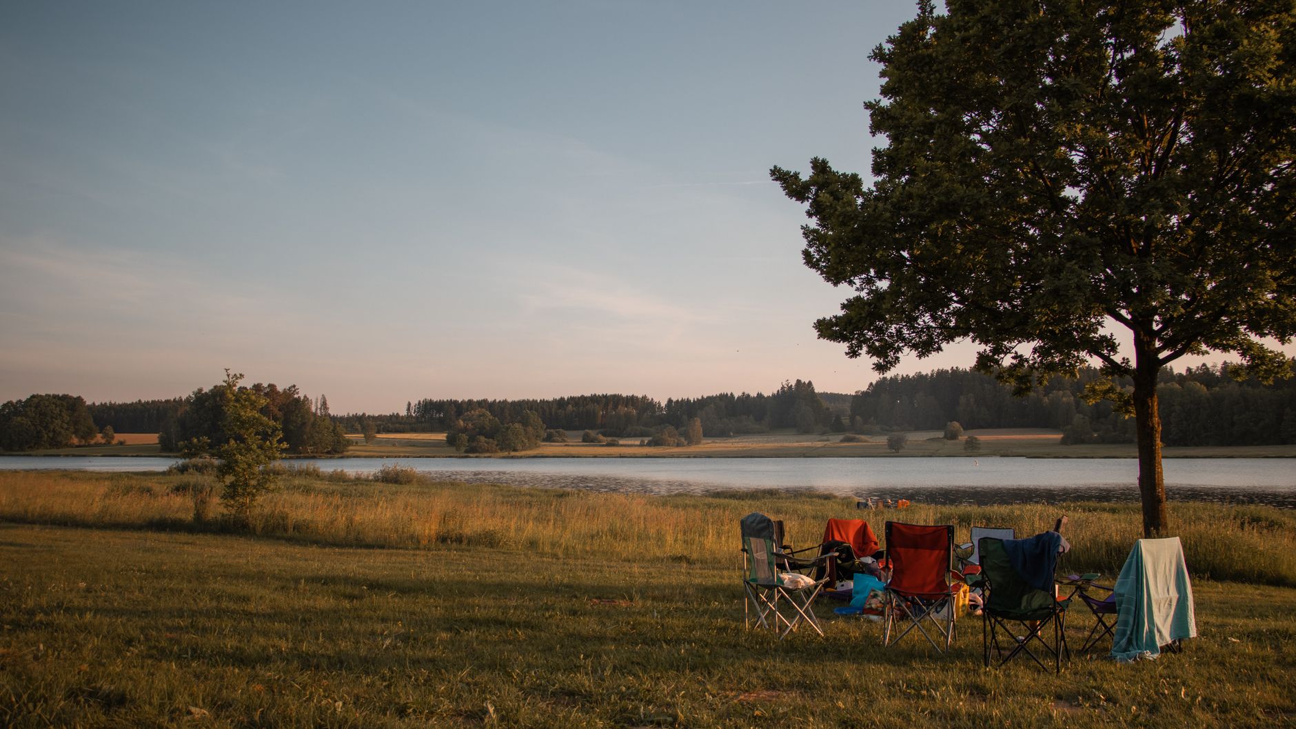 A folding chair set up near a lake