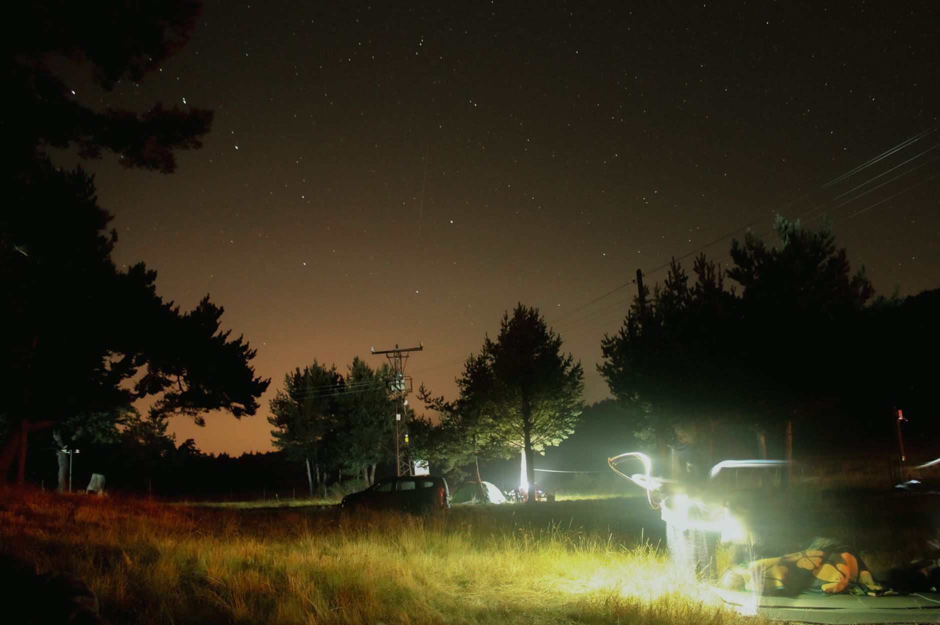 A campsite lit up under a starry sky