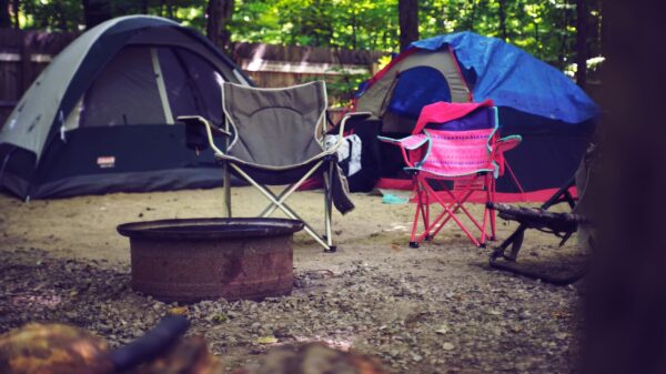 Tents and camp chairs around a fire ring