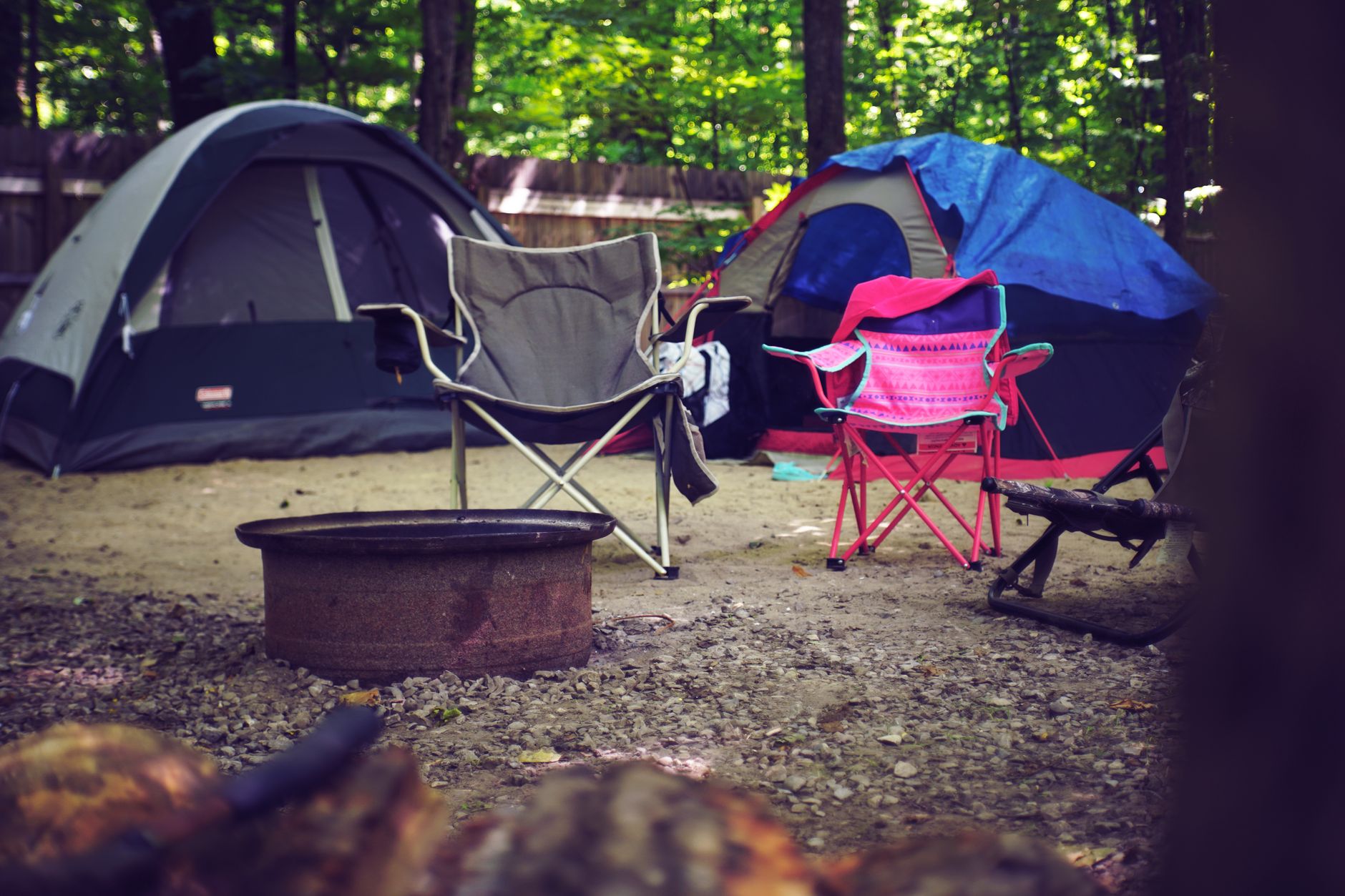 Tents and camp chairs around a fire ring