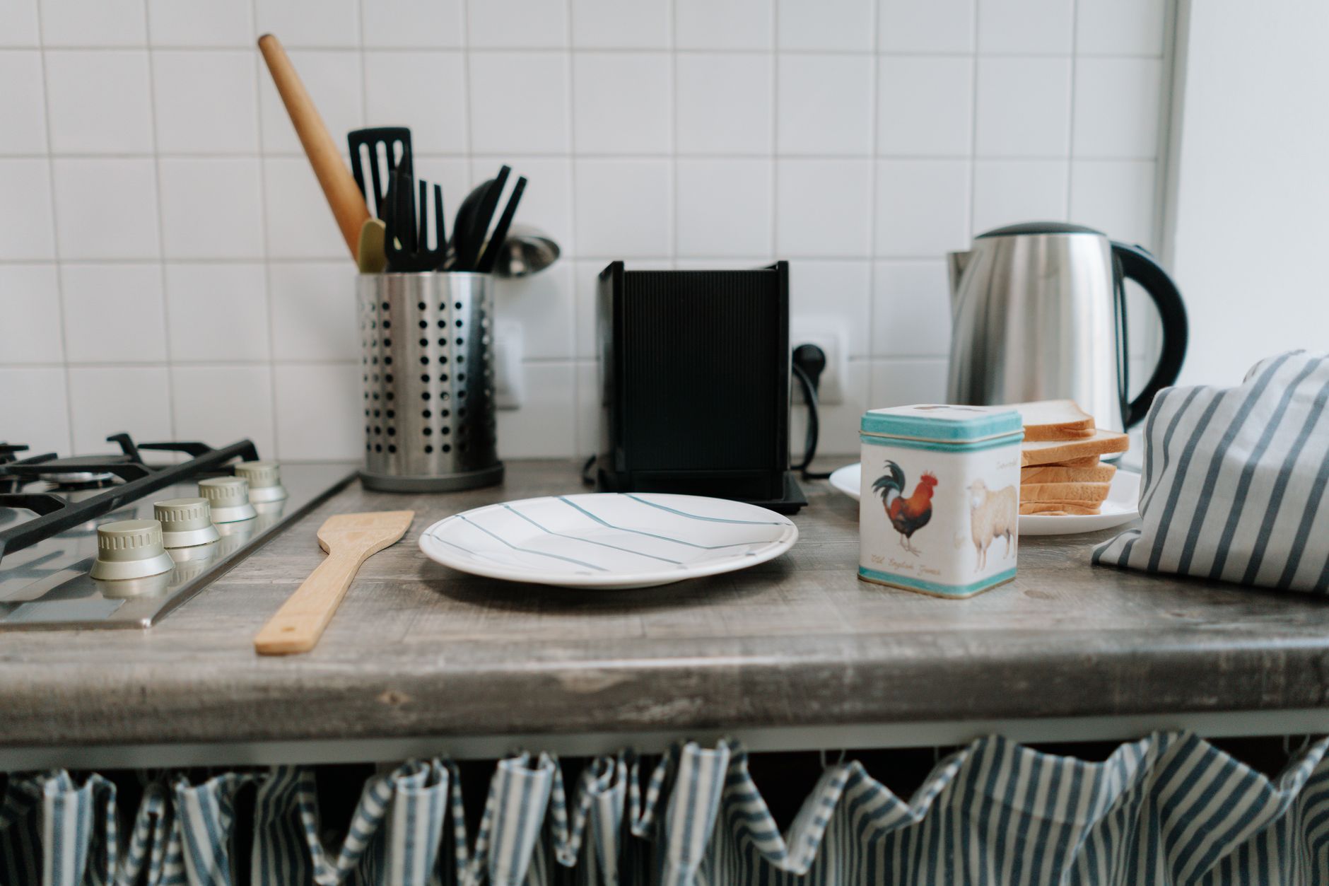 Kitchen utensils and a kettle on a counter