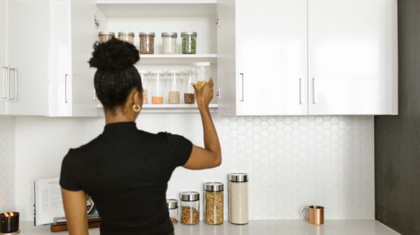 Best can organizer: a woman reaching into a white kitchen cabinet