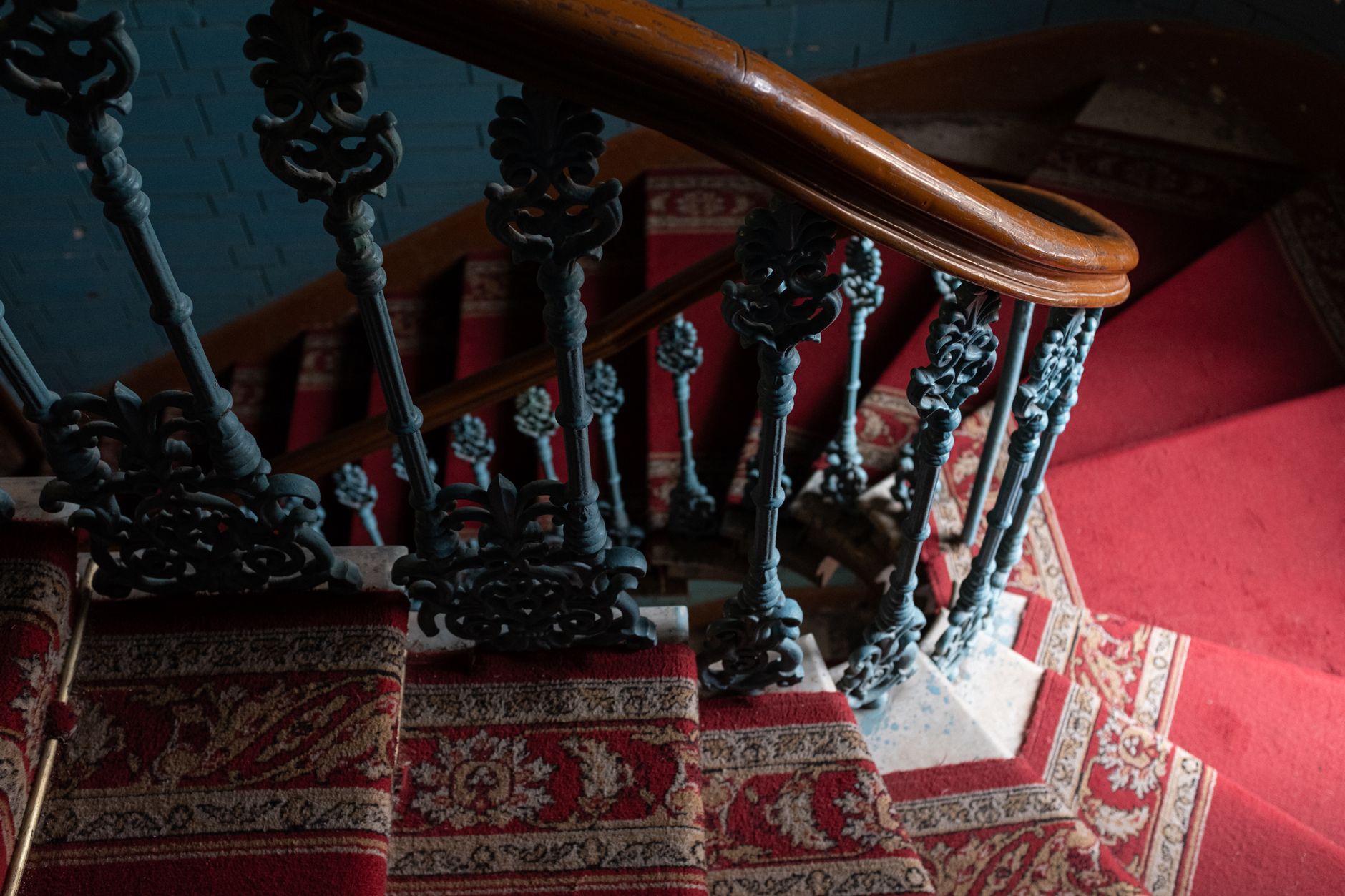 A carpeted staircase with an iron railing